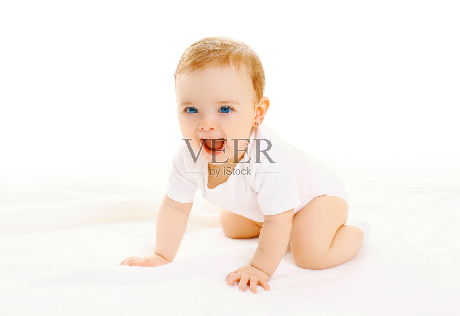快乐的小婴儿在白色的背景上爬行照片摄影图片