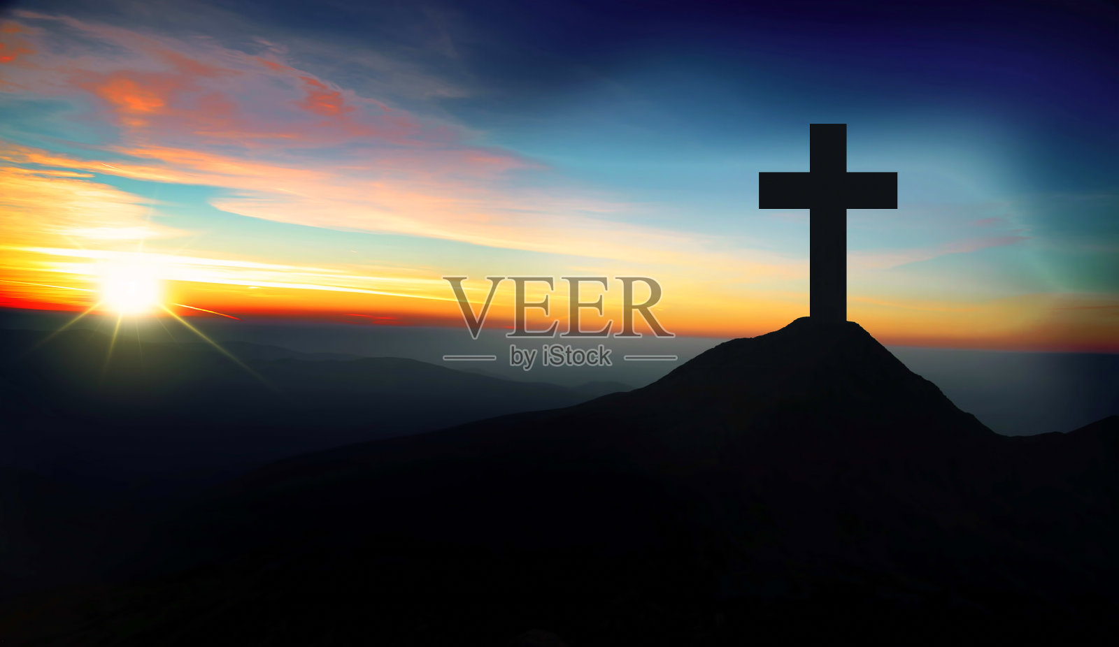 日落时分，山上的基督十字架照片摄影图片