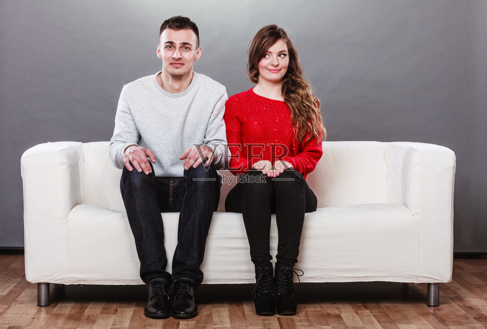 害羞的女人和男人坐在沙发上。第一次约会。照片摄影图片