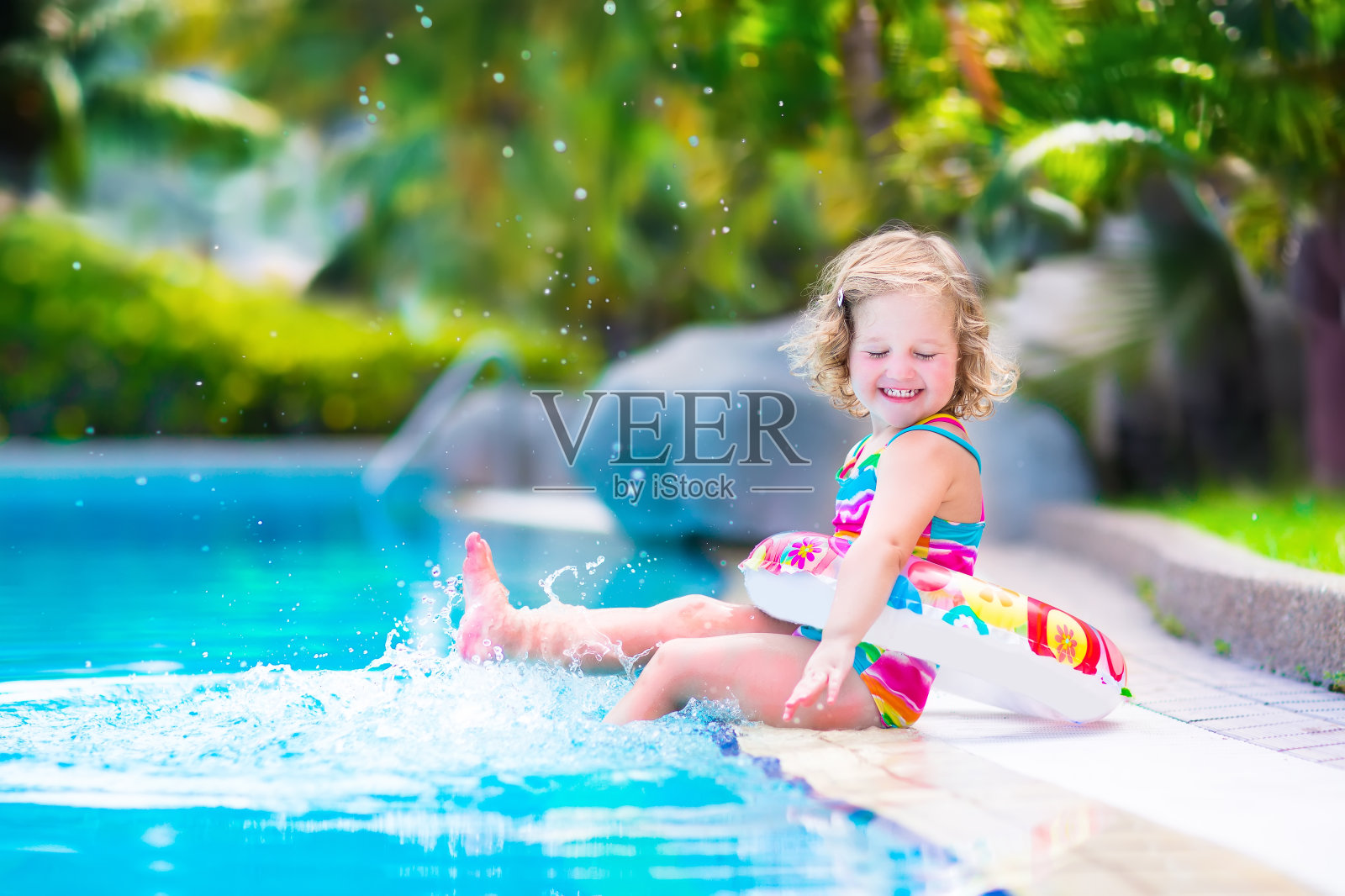 一个快乐的小女孩在游泳池里照片摄影图片