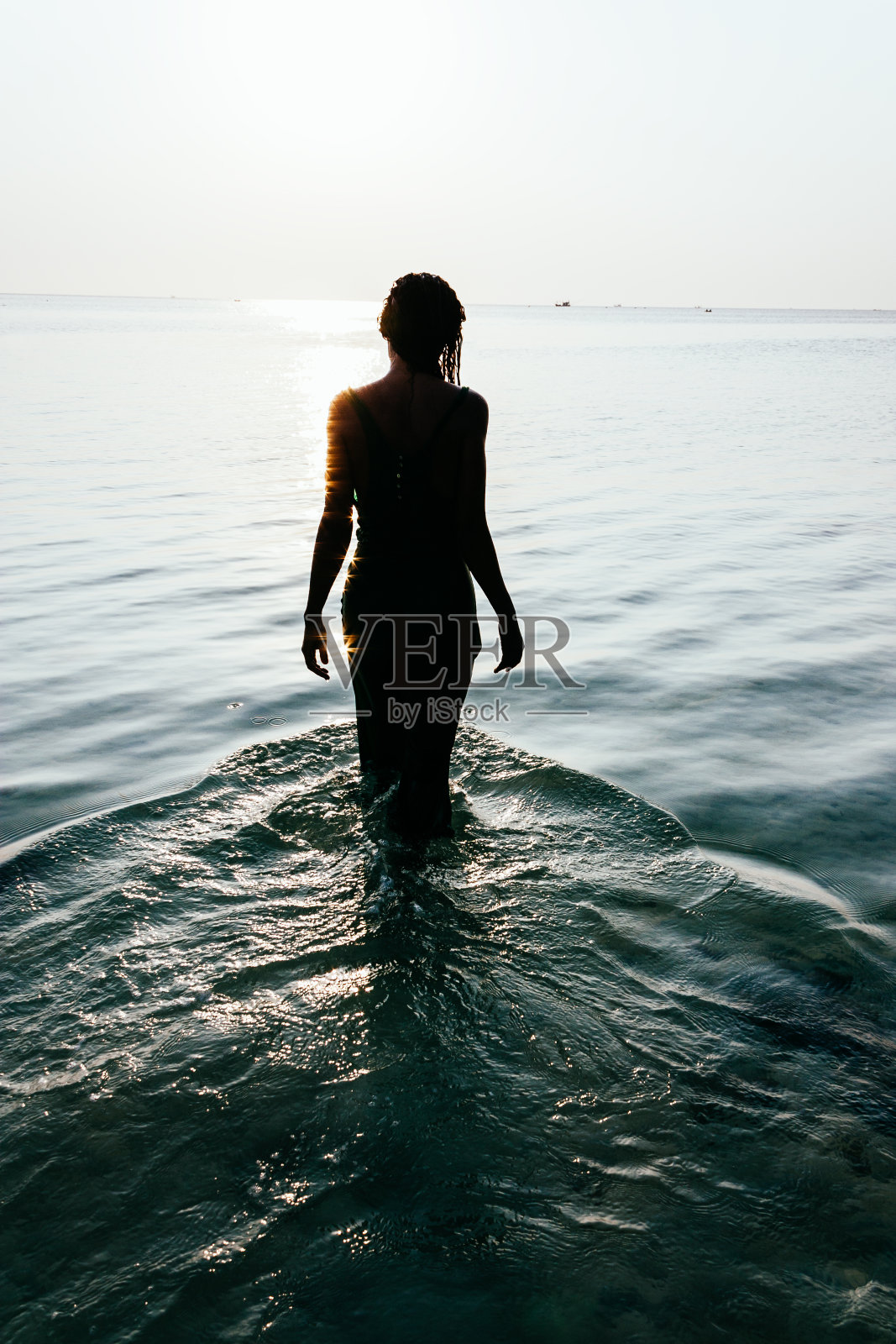 一个湿漉漉的女人站在海里的剪影照片摄影图片