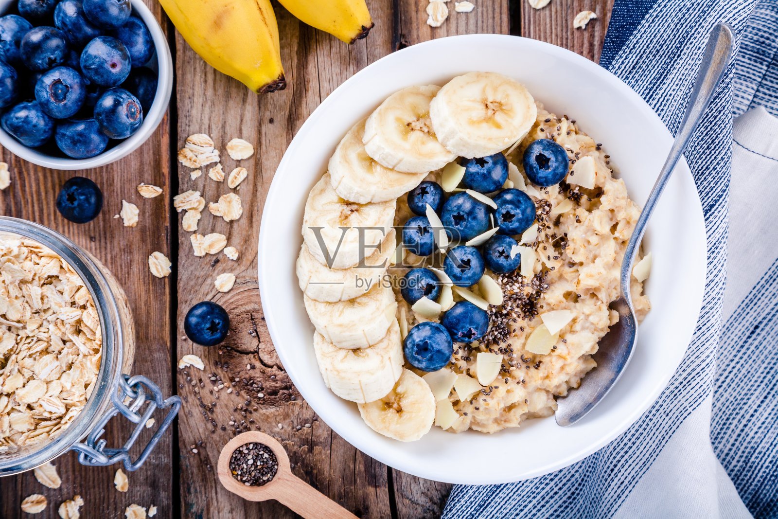 早餐:燕麦片配香蕉、蓝莓、奇异子和杏仁照片摄影图片