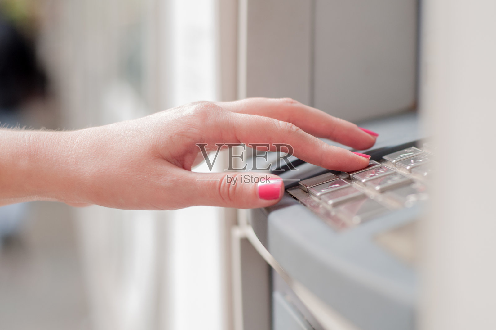 在ATM机输入密码的手的特写。照片摄影图片