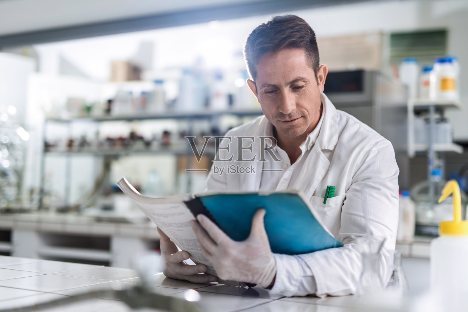 男性化学家在实验室阅读医学数据。照片摄影图片