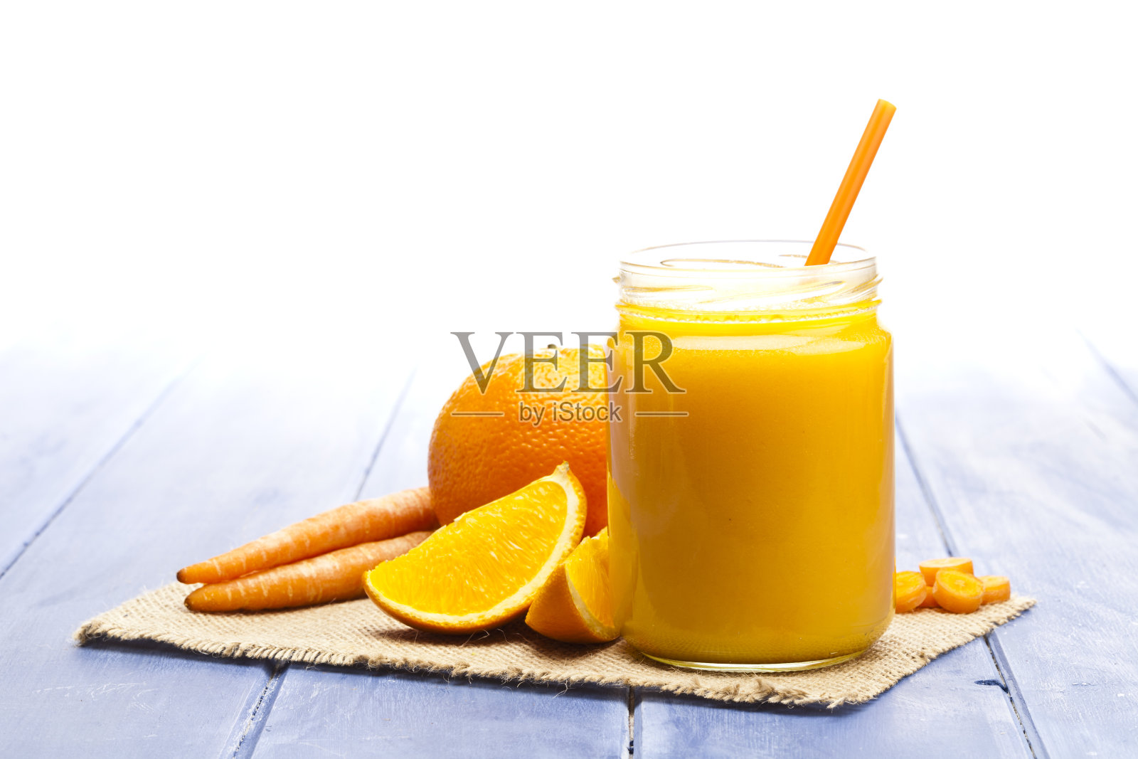 装有橙汁和胡萝卜汁的玻璃罐子照片摄影图片