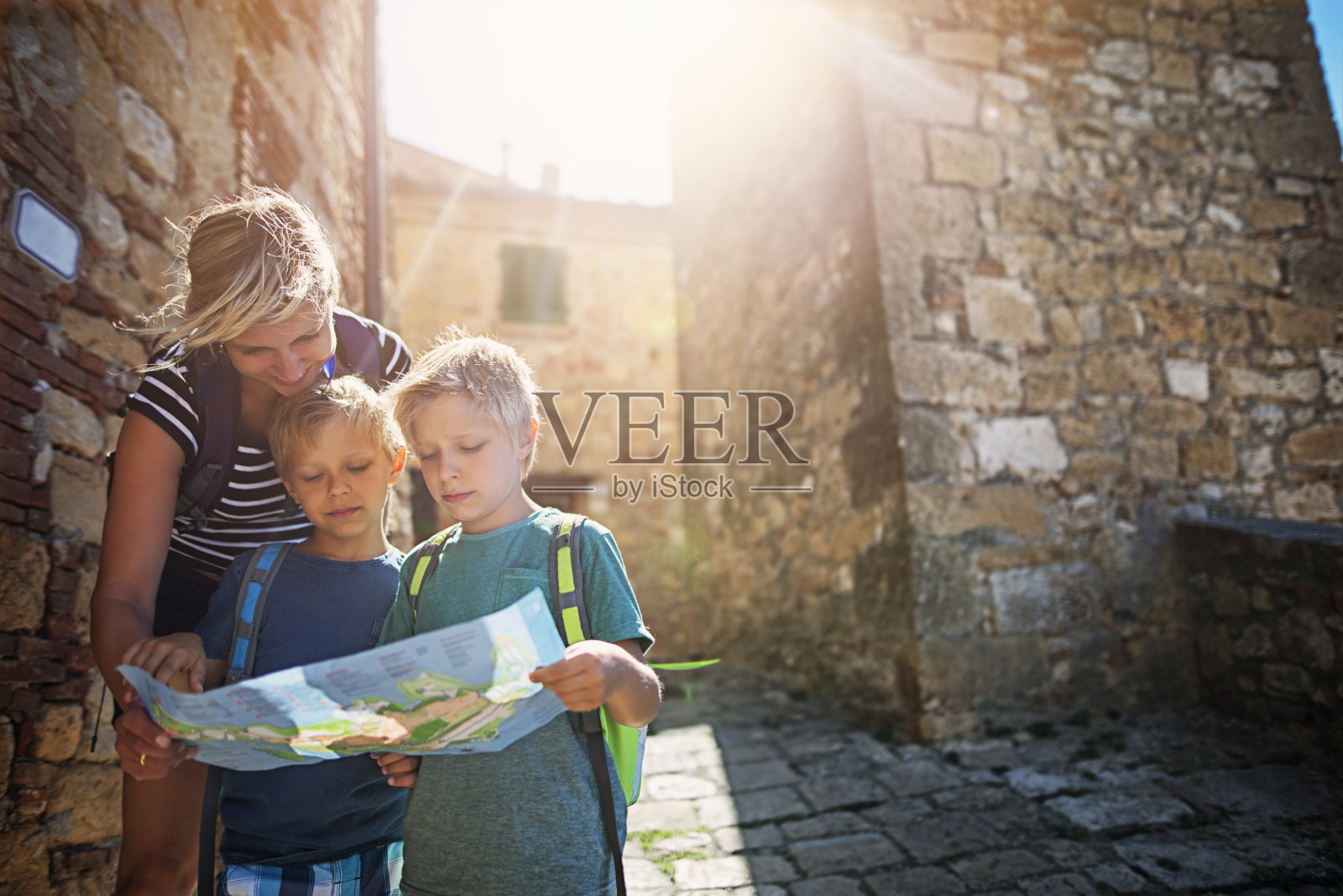母亲和旅游的儿子在意大利的一个小镇上查看地图照片摄影图片
