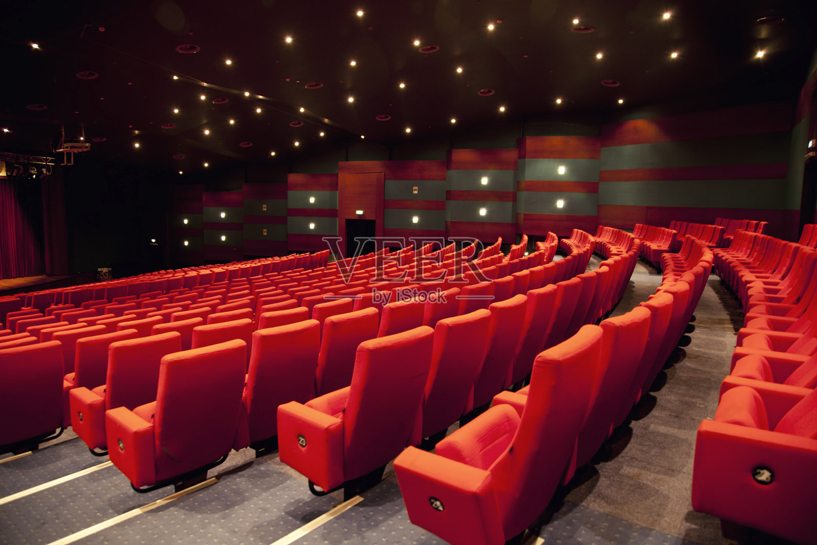 一个空的低灯光的剧院，有一排排的红色座位照片摄影图片