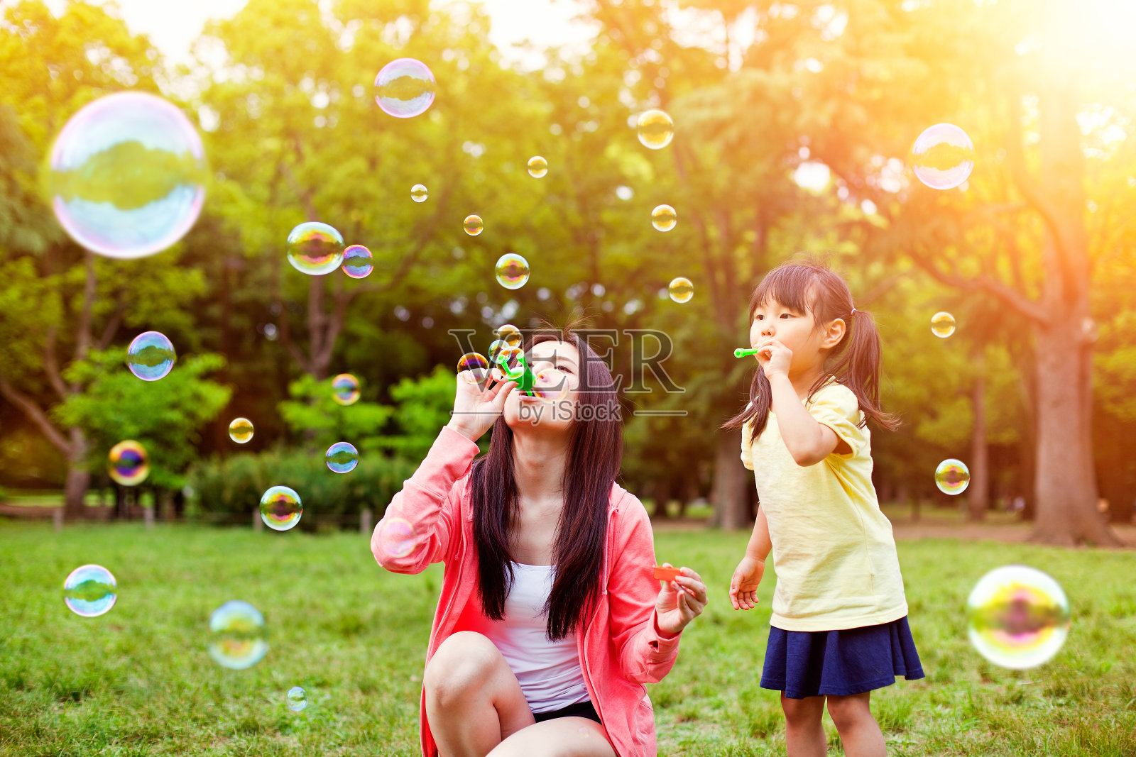 妈妈和女儿在公园和肥皂泡玩得开心照片摄影图片