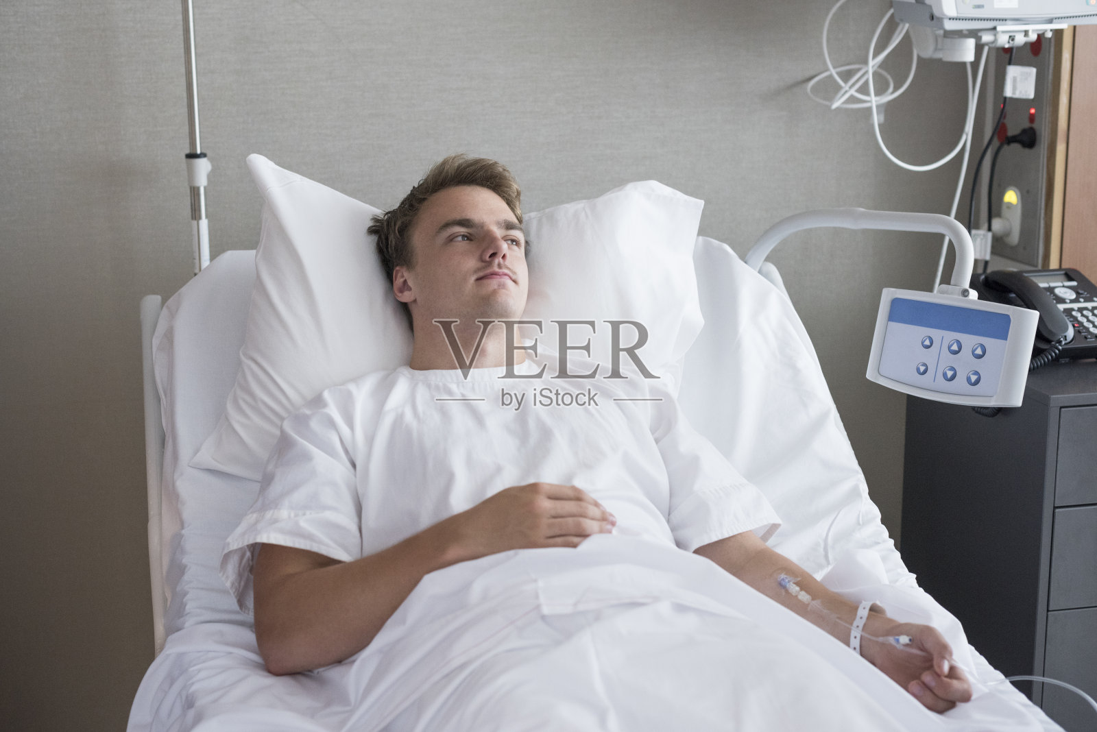 男病人躺在病床上，正在输液照片摄影图片