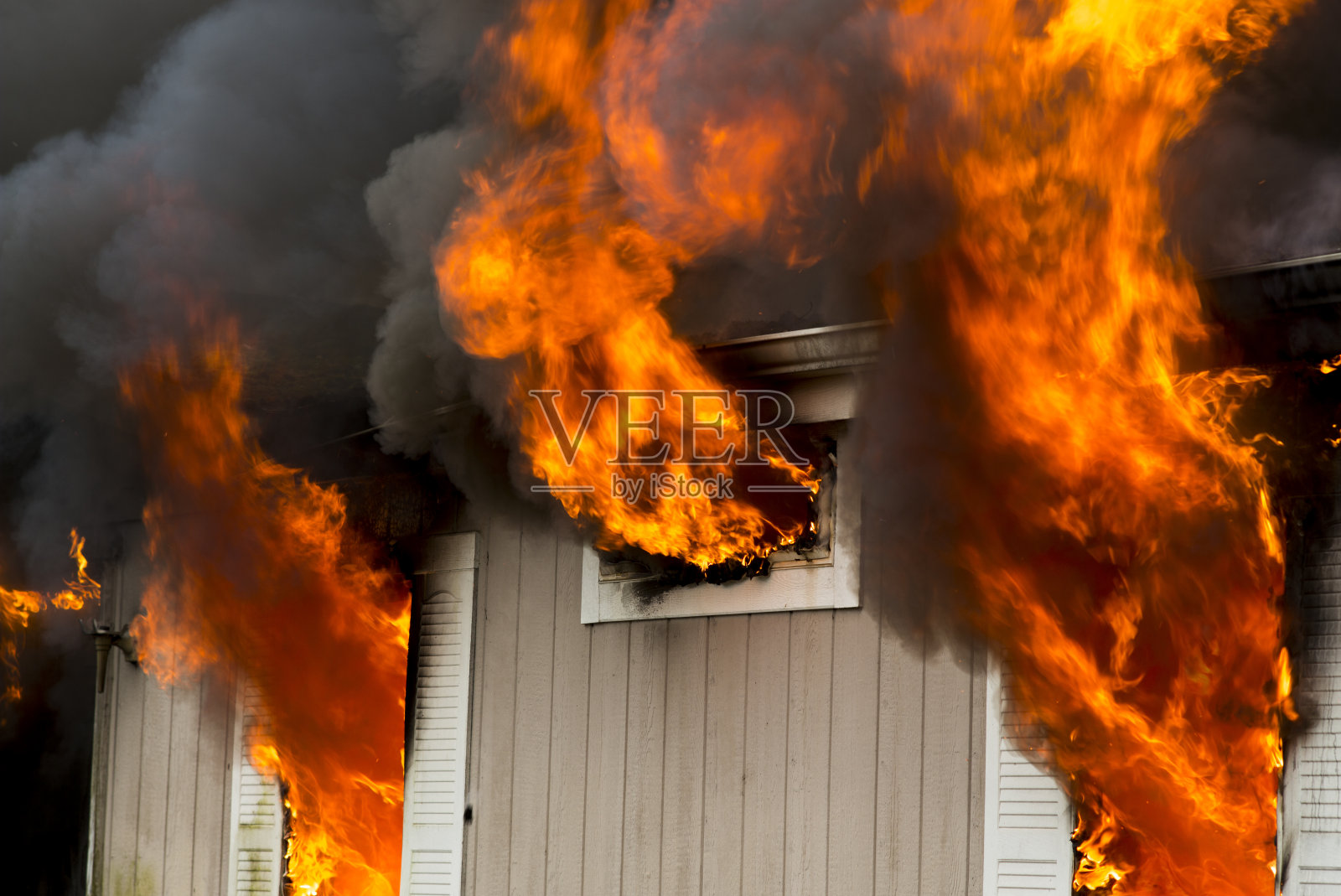 燃烧中的房屋从窗户中喷出火焰照片摄影图片