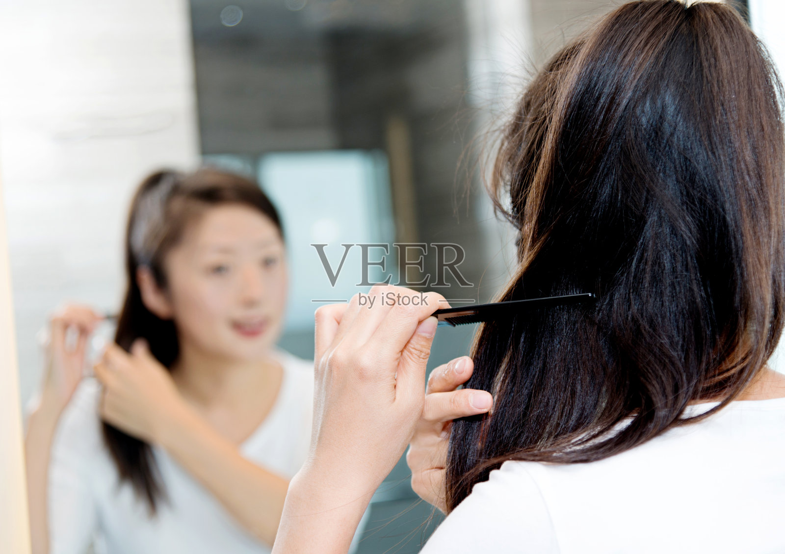 年轻女子在梳理她的头发照片摄影图片