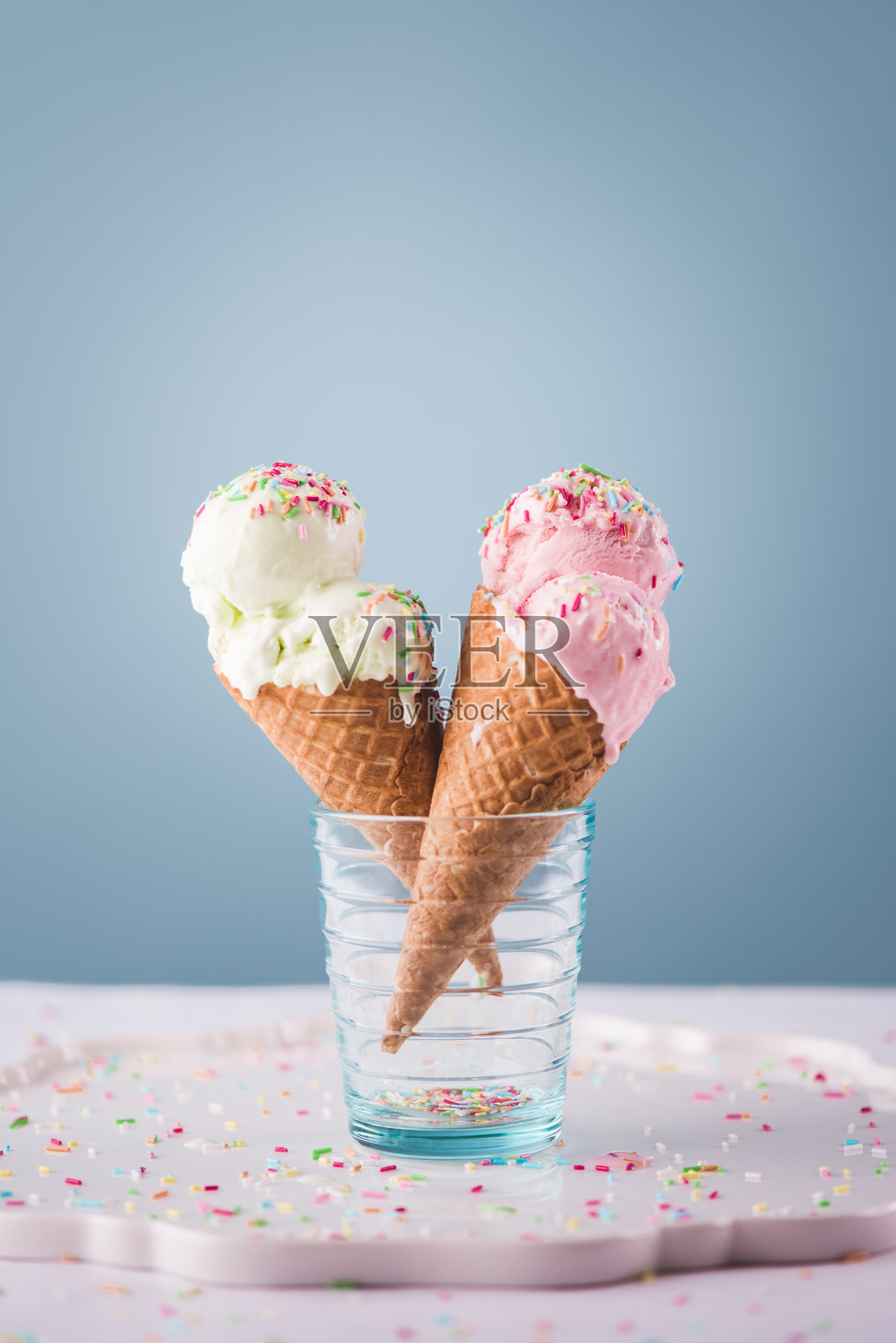 蓝色背景上的草莓和梨冰淇淋蛋卷照片摄影图片
