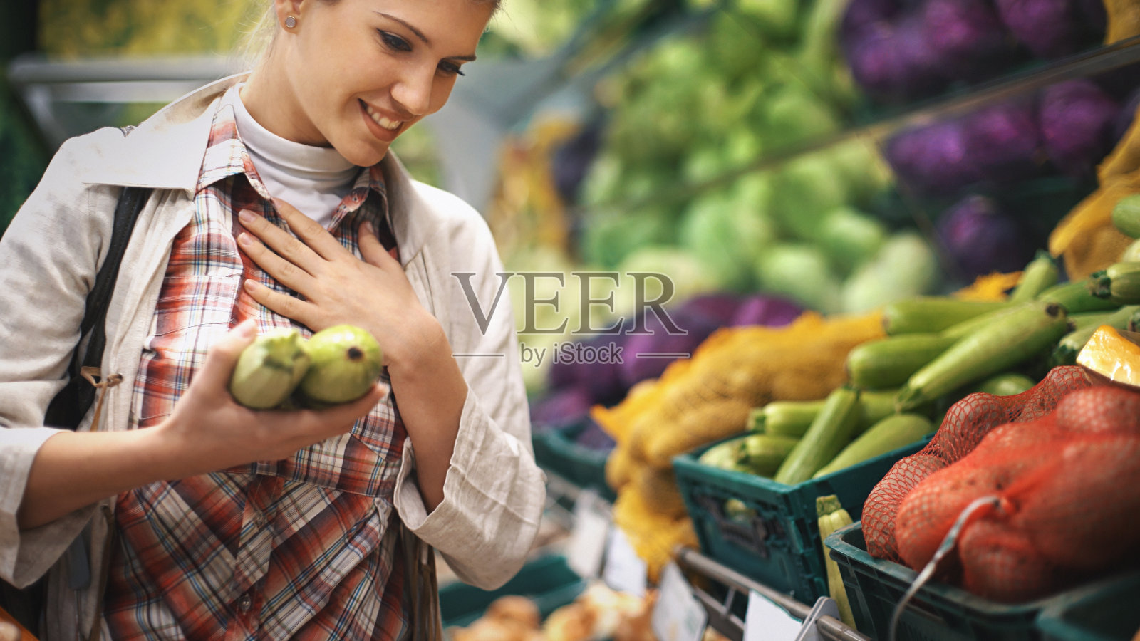 在超市买蔬菜的女人。照片摄影图片