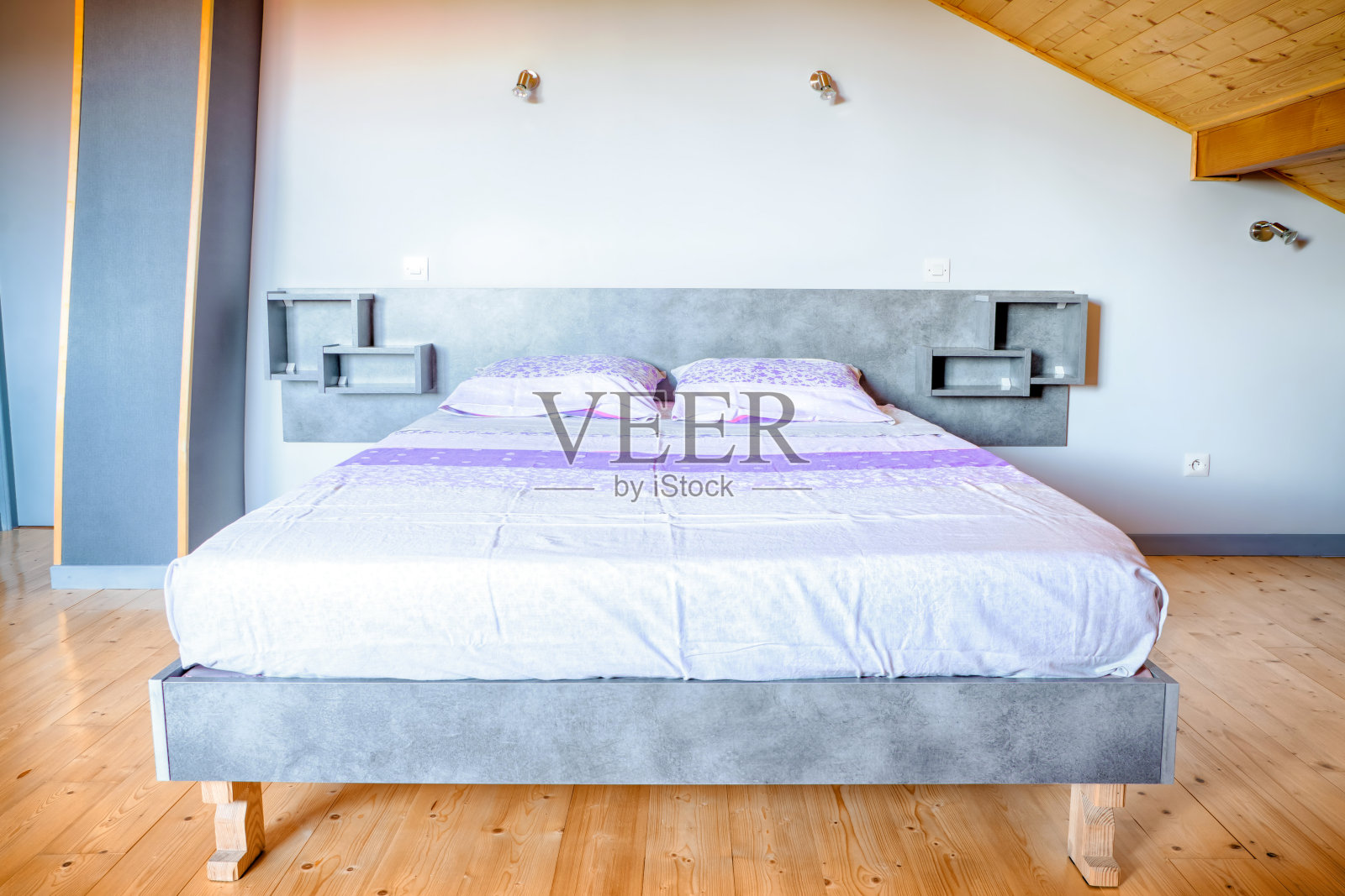 简单的自制床基础室内景观与两个人床垫和复古亮紫色床单纺织在一个大的稀疏房间楼上拼花木地板照片摄影图片