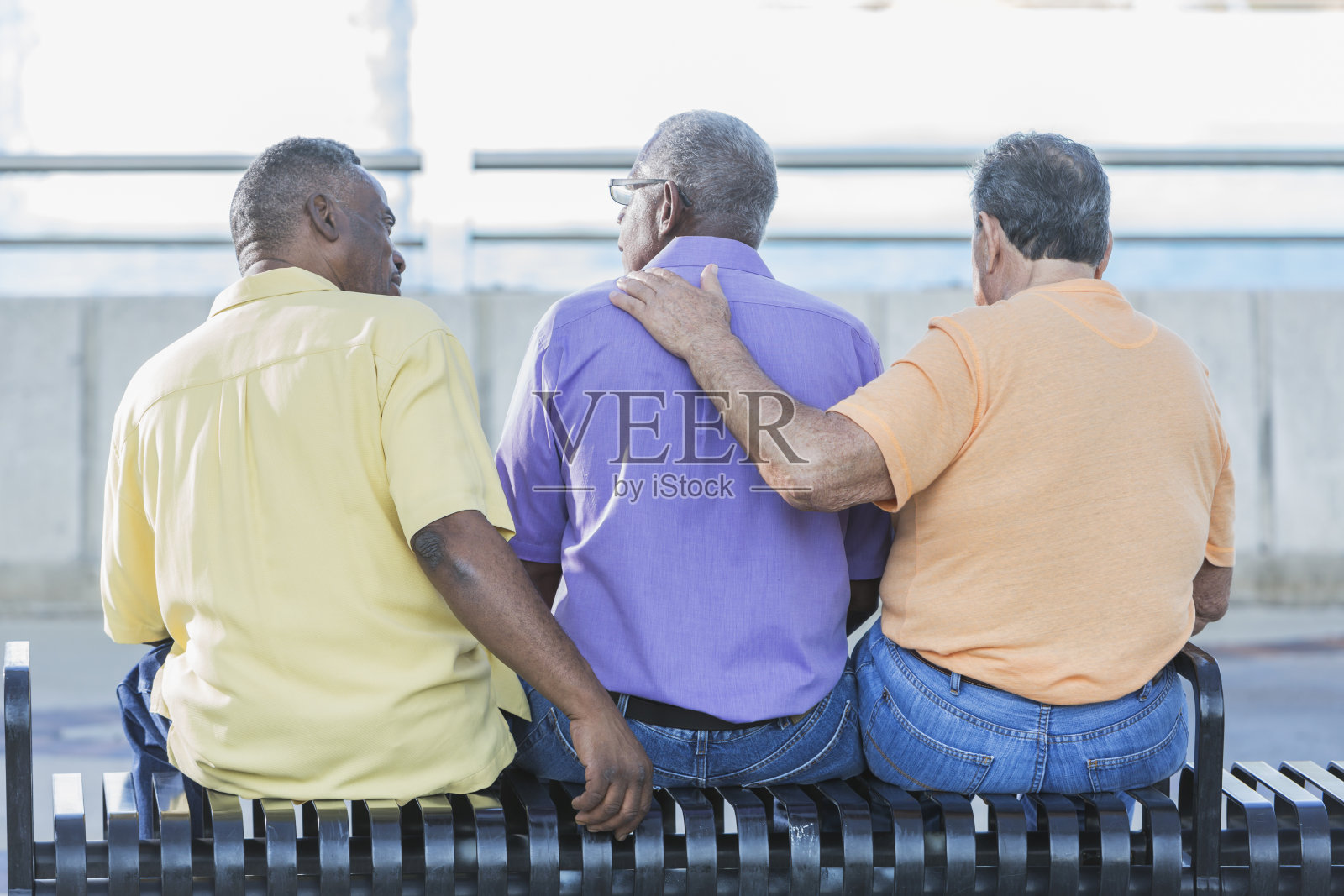 三位来自不同种族的资深男士坐在长凳上照片摄影图片