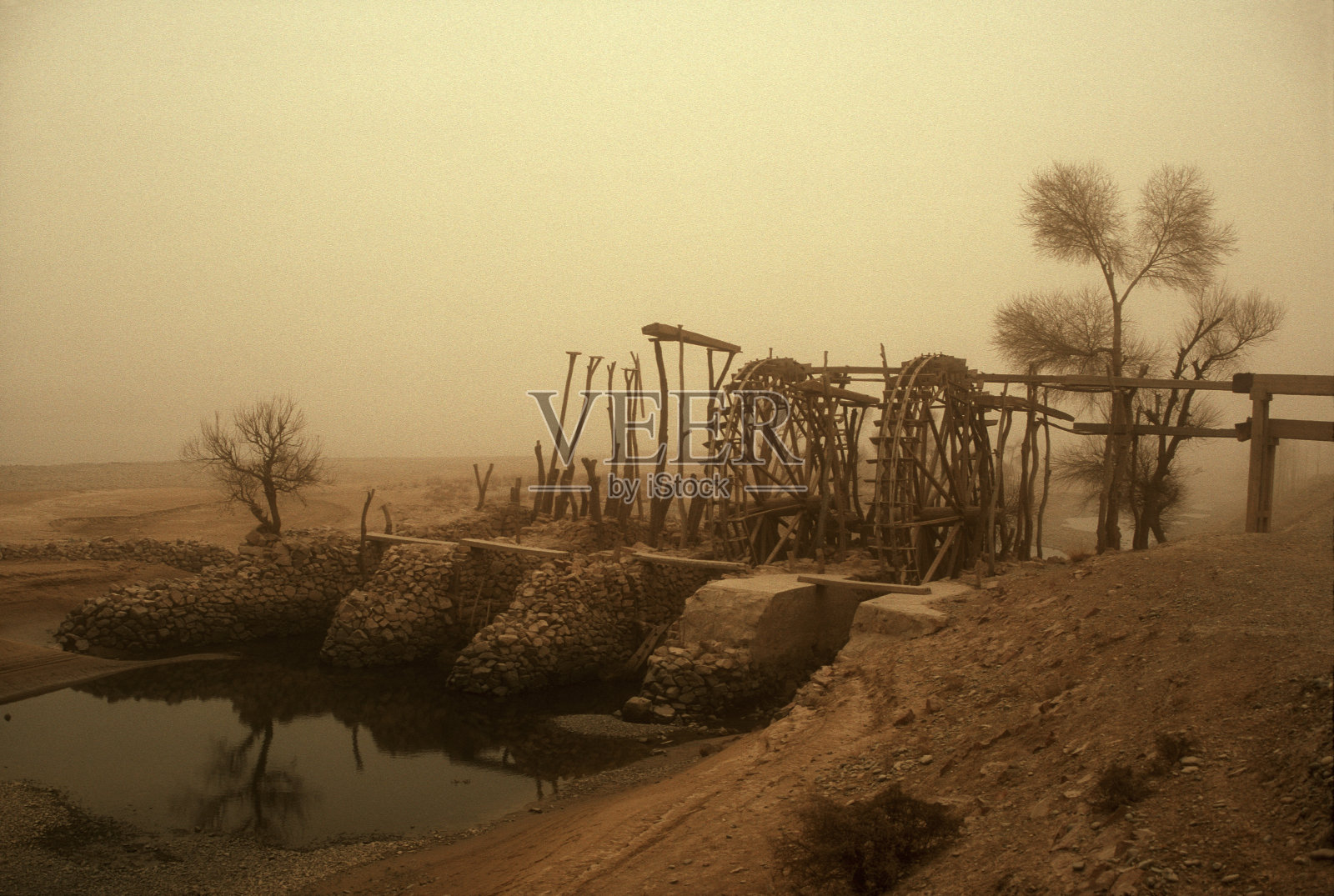 中国古代风沙中的水车照片摄影图片