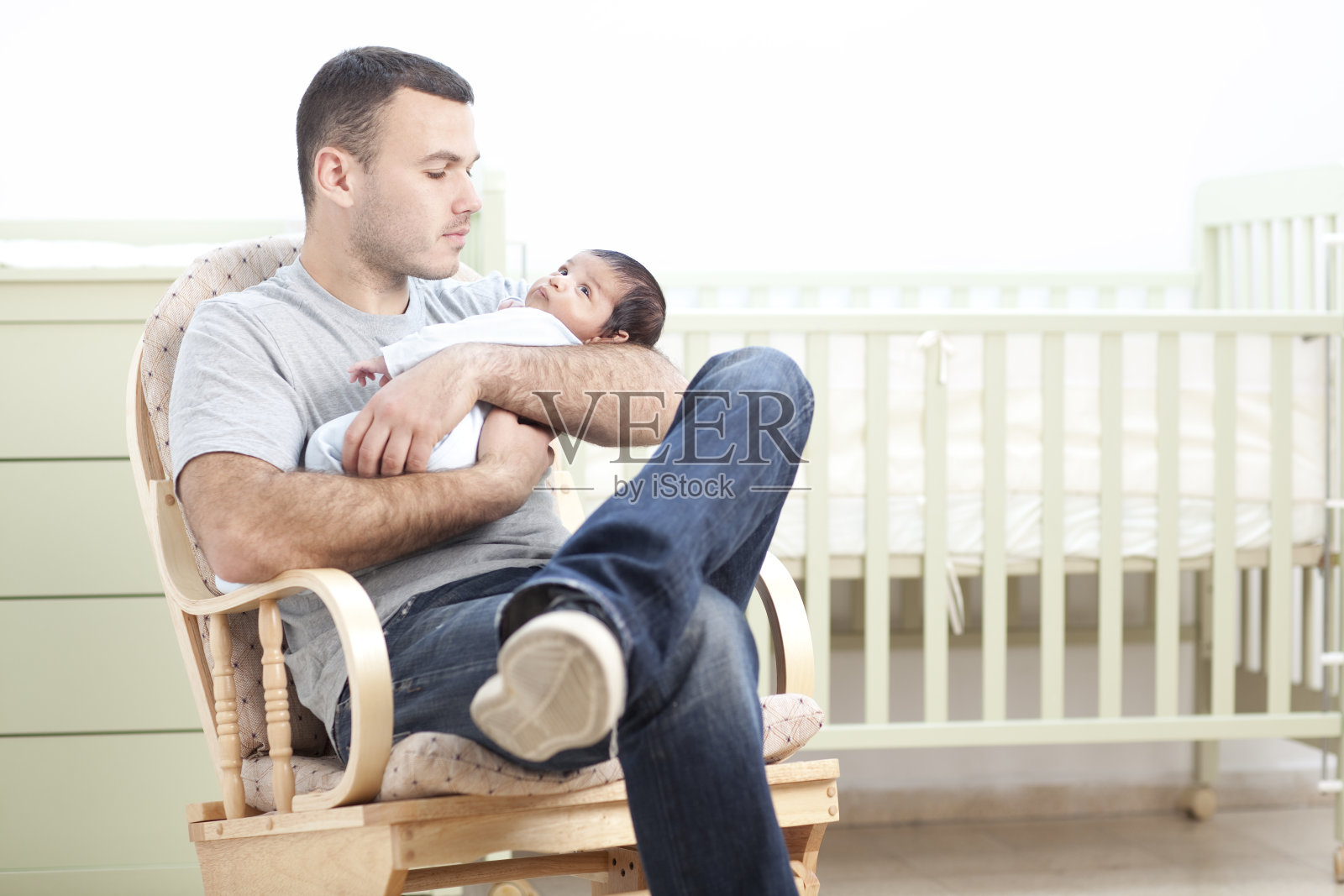 一位父亲抱着刚出生的婴儿坐着照片摄影图片