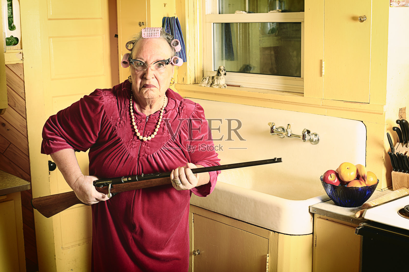 在厨房拿枪的坏脾气奶奶照片摄影图片