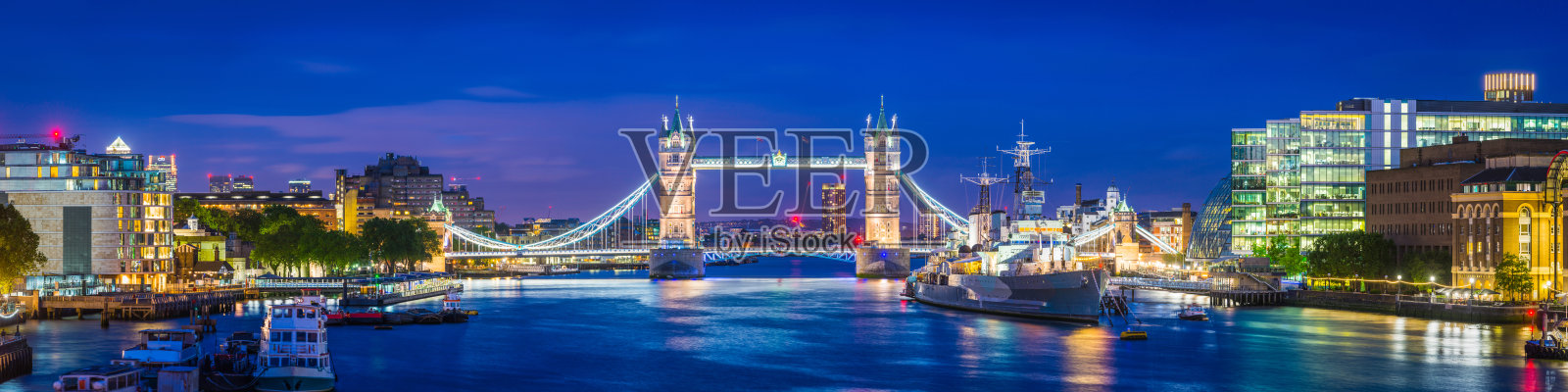 伦敦塔桥和泰晤士河堤岸在黄昏被照亮的全景照片摄影图片