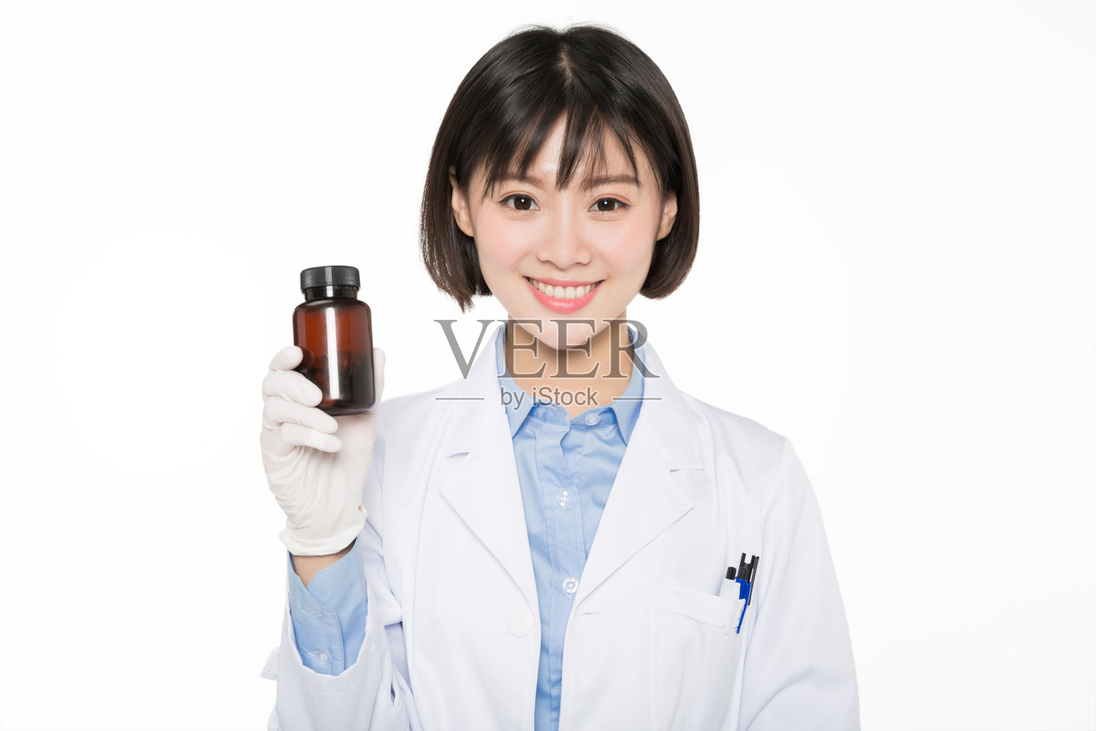 一个穿着实验服，拿着药瓶的女人照片摄影图片