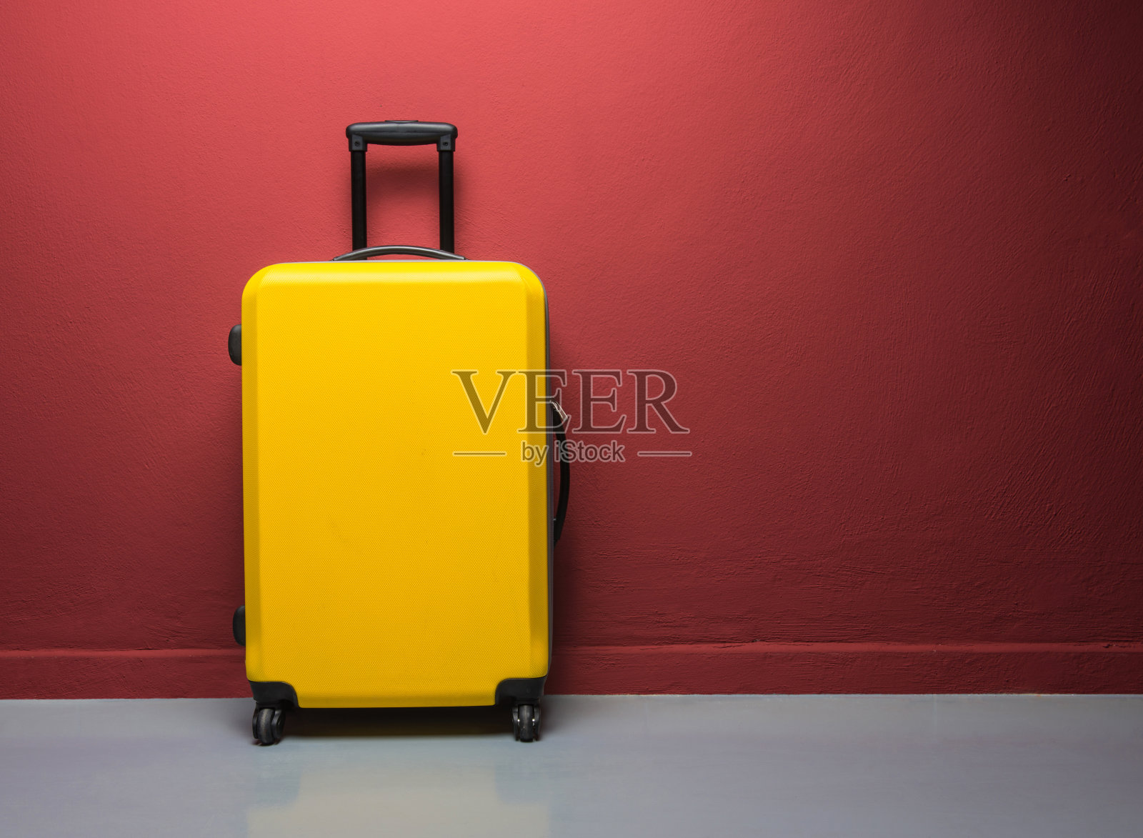 红色墙壁上的黄色提手手提箱照片摄影图片