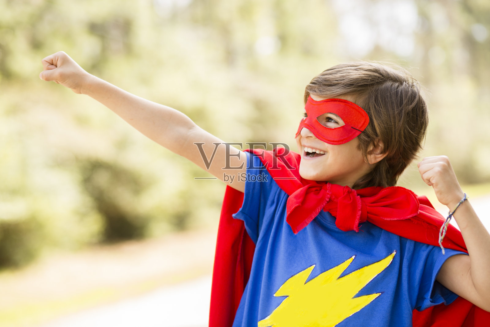 小男孩在户外玩超级英雄。假装,装扮。照片摄影图片