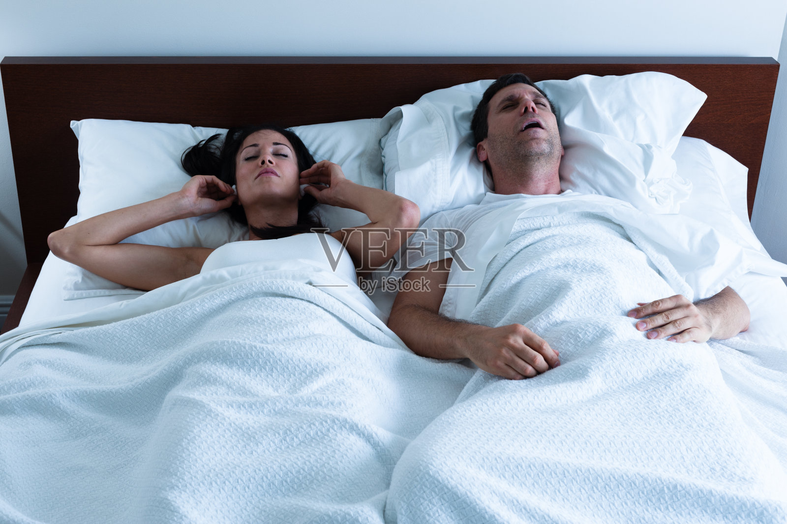 打鼾的男人和妻子在床上照片摄影图片