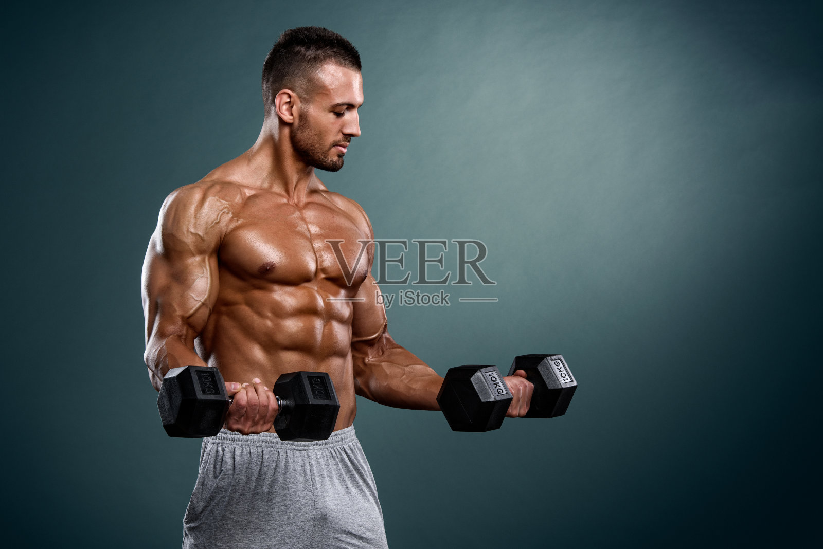 英俊的肌肉男用重量锻炼照片摄影图片