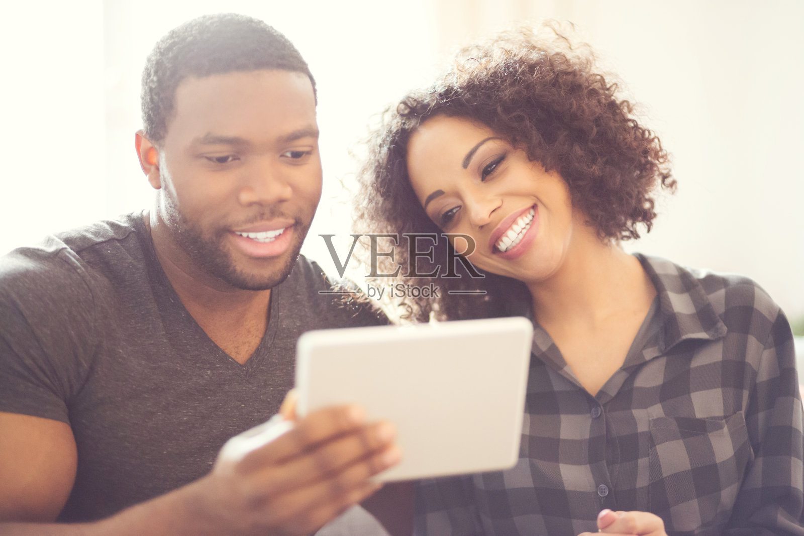 快乐的非洲裔美国夫妇在家里使用数码平板电脑照片摄影图片