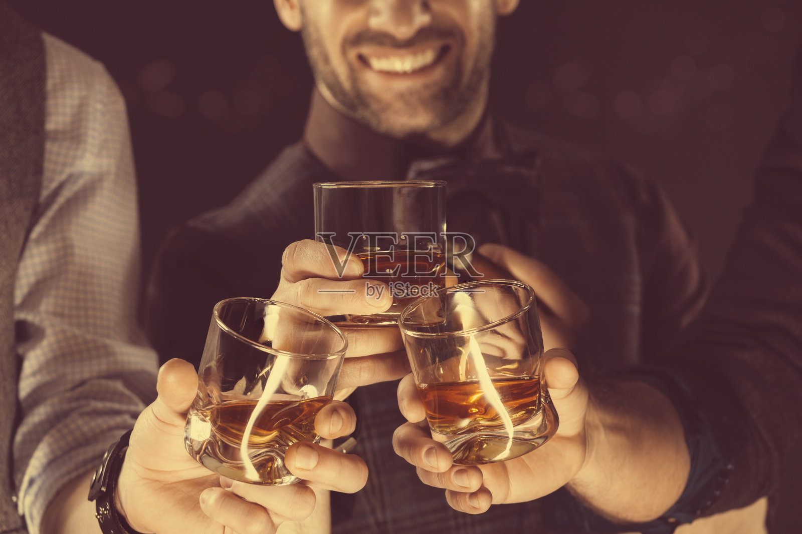 男人们喝着威士忌，靠近杯子和手照片摄影图片