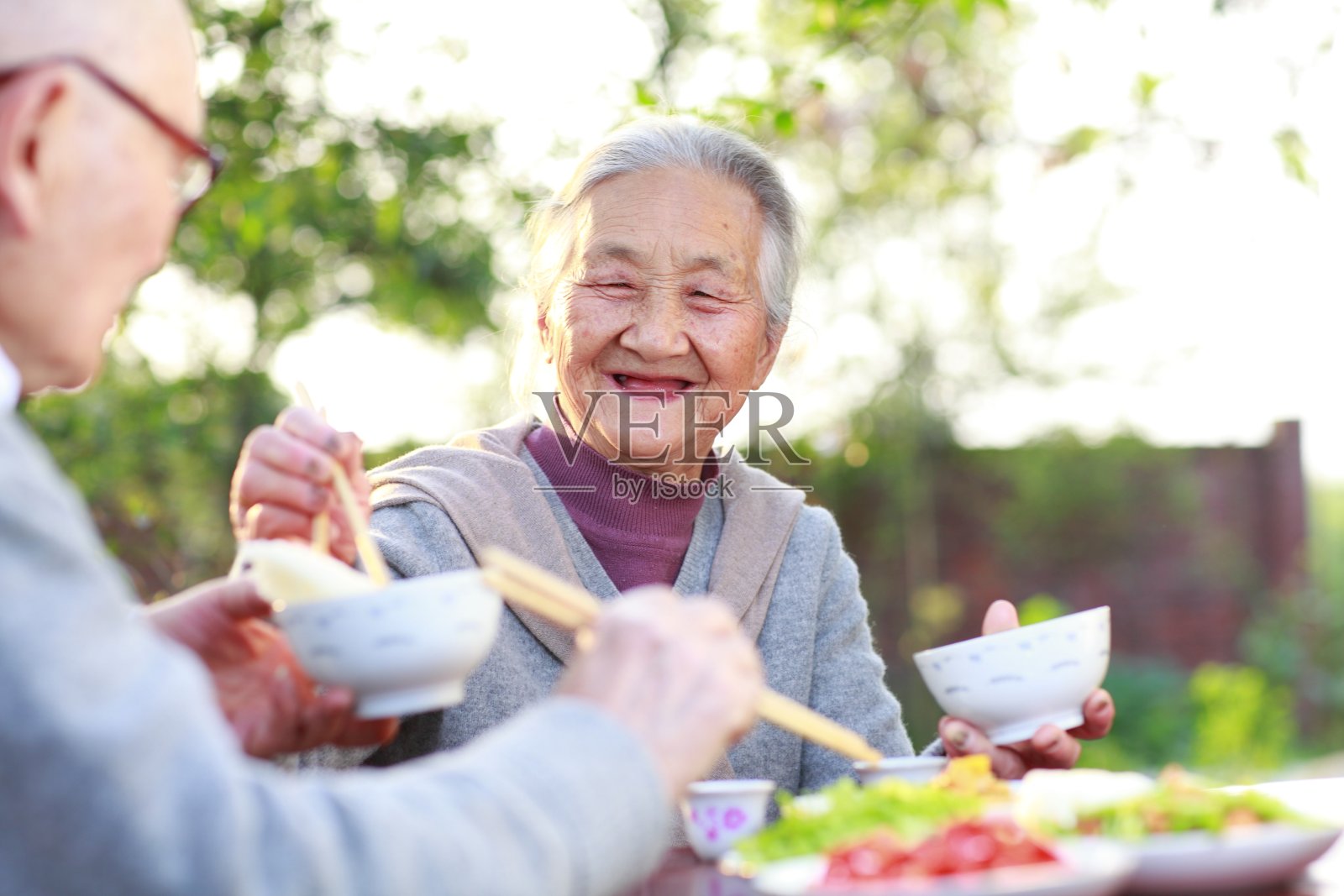 快乐的亚洲老夫妇在院子里吃饭照片摄影图片