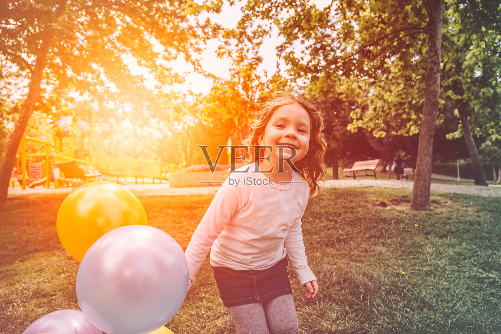 快乐的小女孩玩彩色的气球照片摄影图片