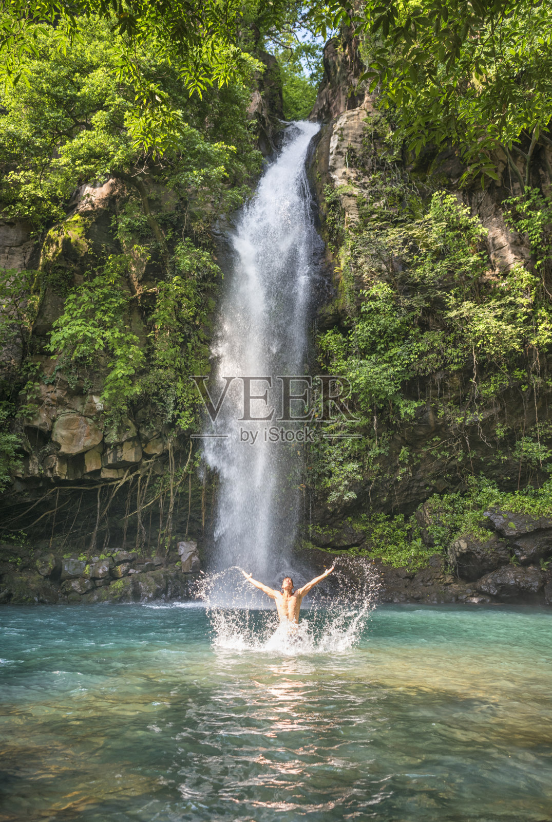 哥斯达黎加，一名男子在瀑布中沐浴照片摄影图片