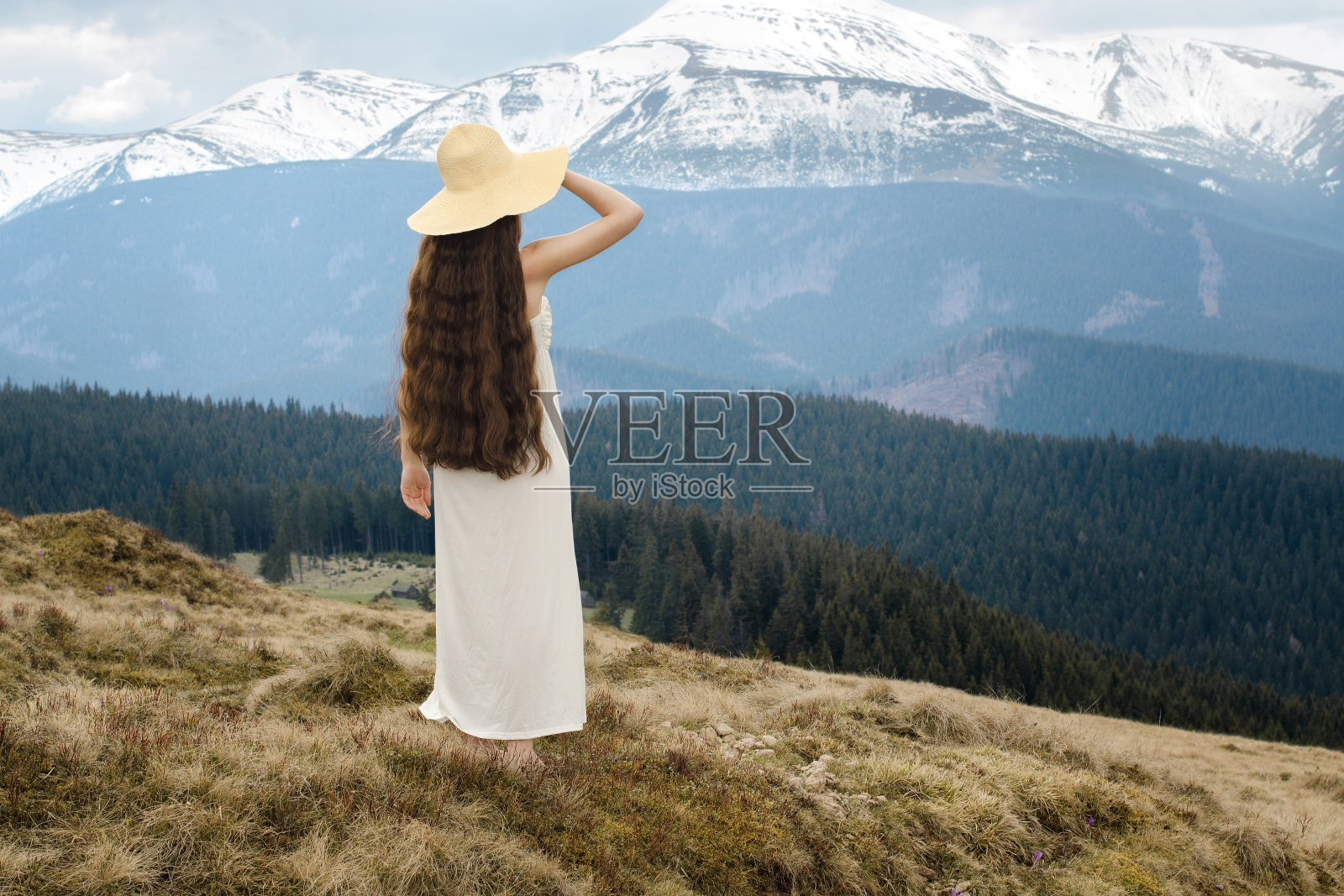 年轻女子站在山的山坡上照片摄影图片