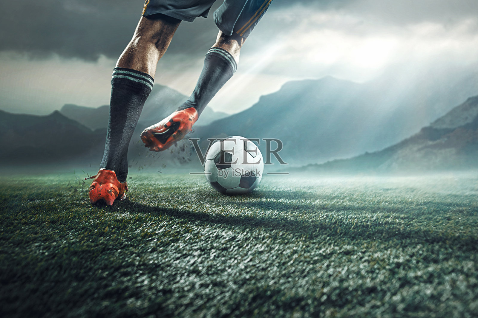 足球运动员踢球时的腿照片摄影图片