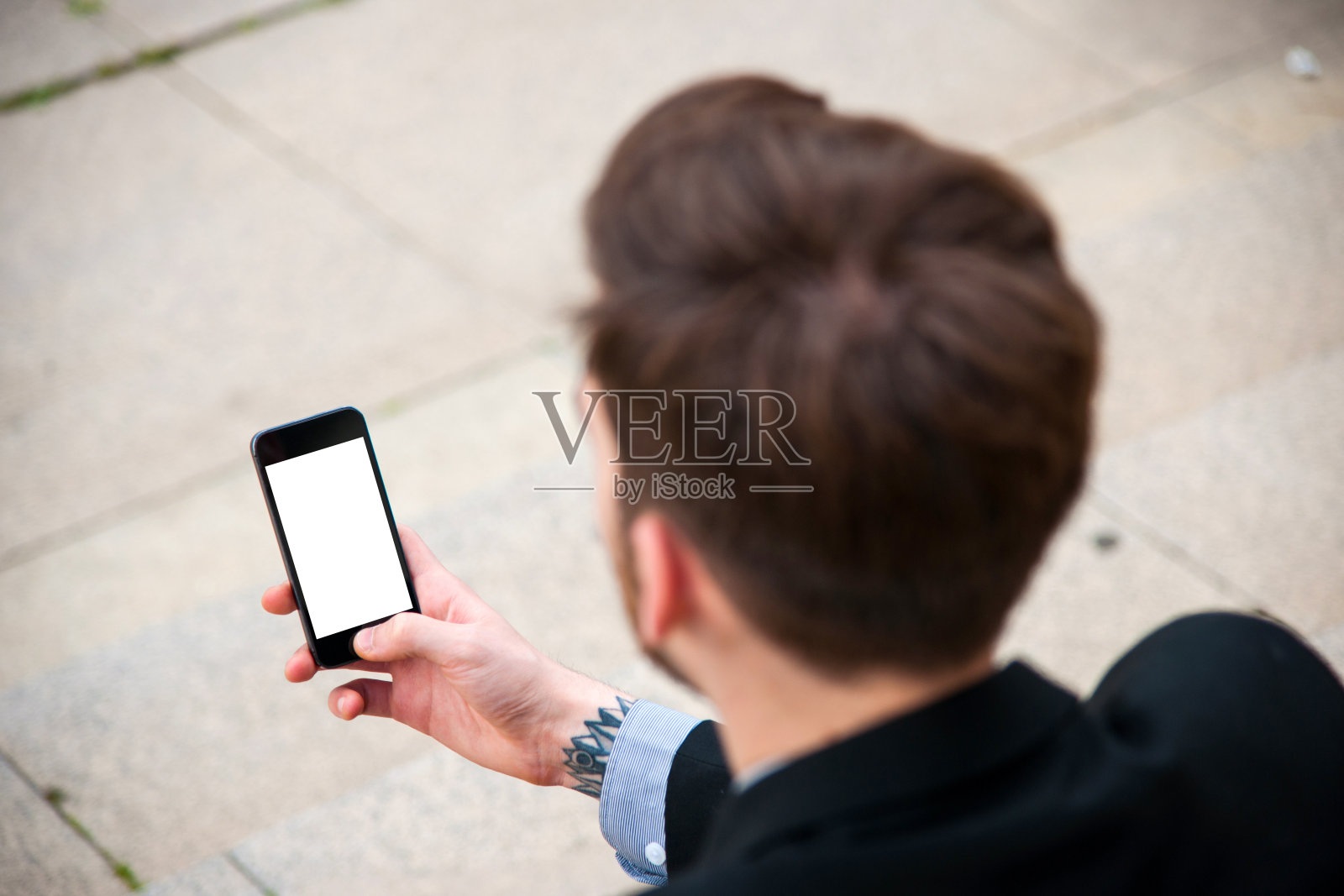 年轻商人在户外使用黑屏智能手机照片摄影图片