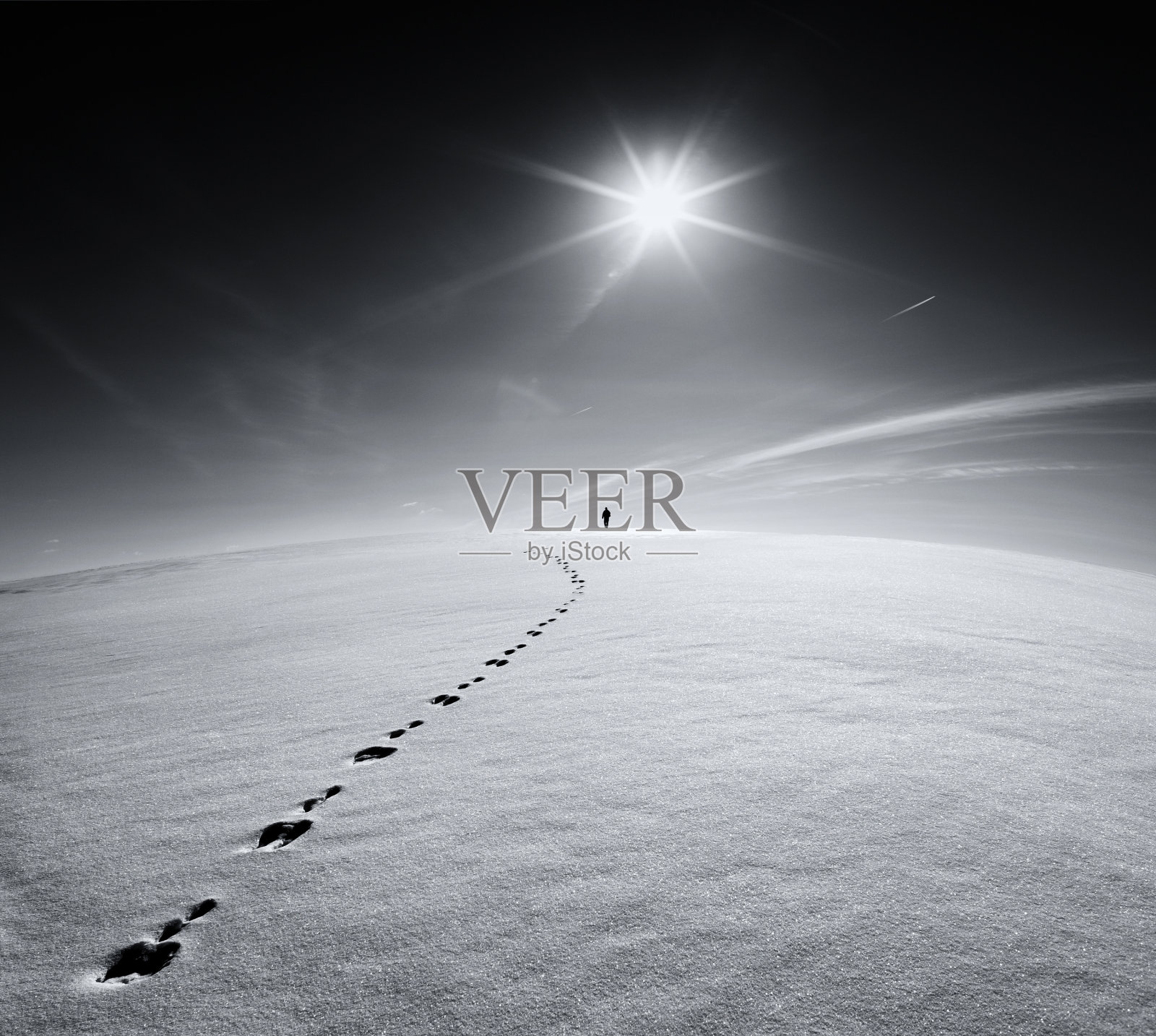 人，地球，宇宙，一个孤独的人走在雪地上，在太阳和飞行飞机的背景上，沿着野兔的足迹行走照片摄影图片