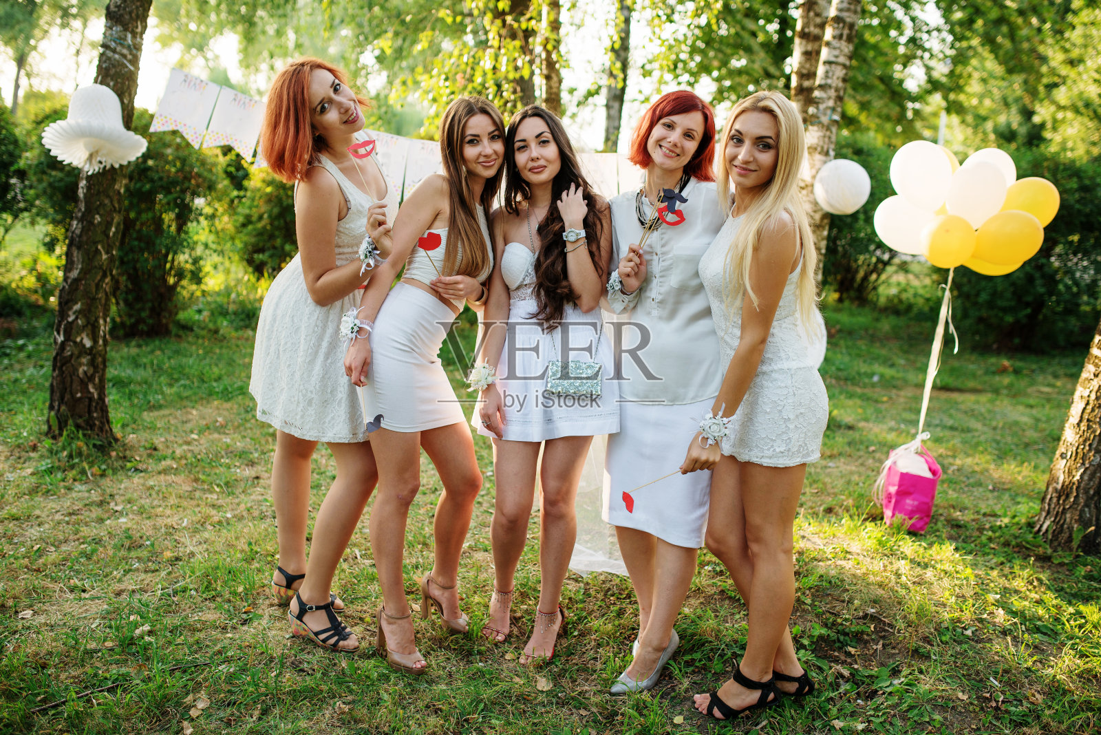 女孩们穿着白色的裙子在女性聚会上玩。照片摄影图片