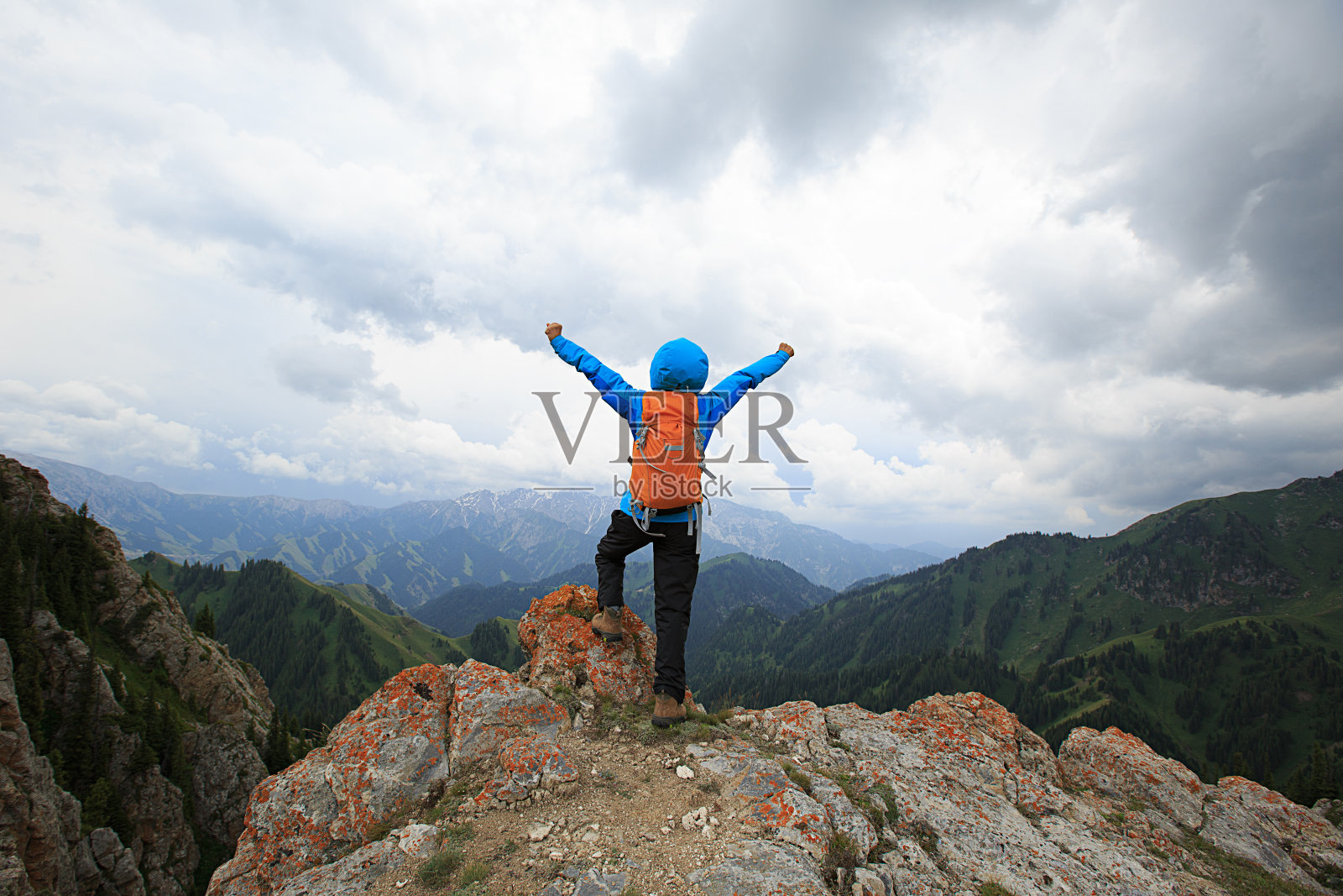 成功的女性徒步旅行者在山顶悬崖张开双臂照片摄影图片