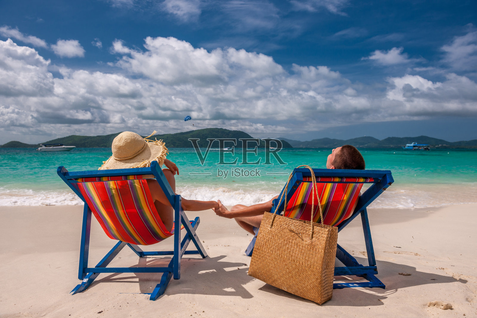一对穿着躺椅在热带海滩上的情侣照片摄影图片