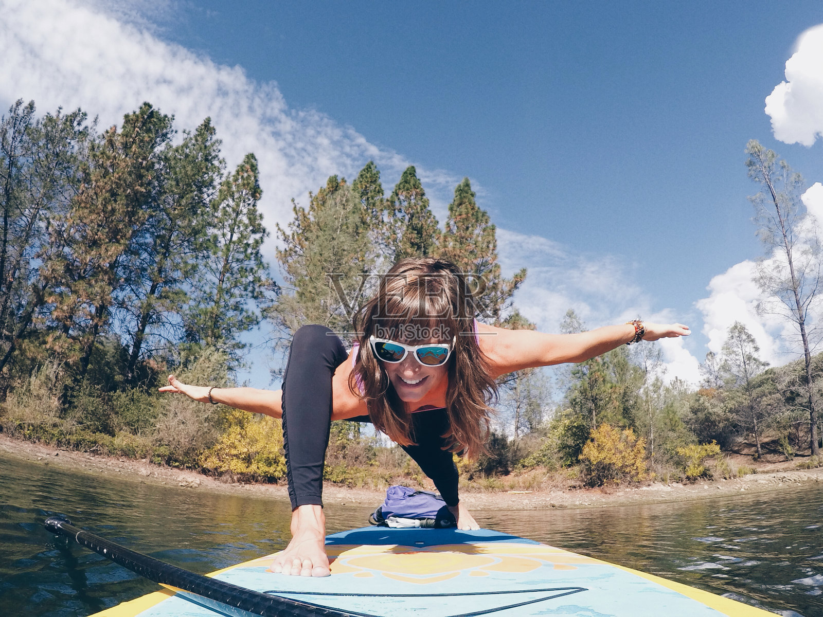 一个女人在湖中划桨板上做瑜伽姿势照片摄影图片