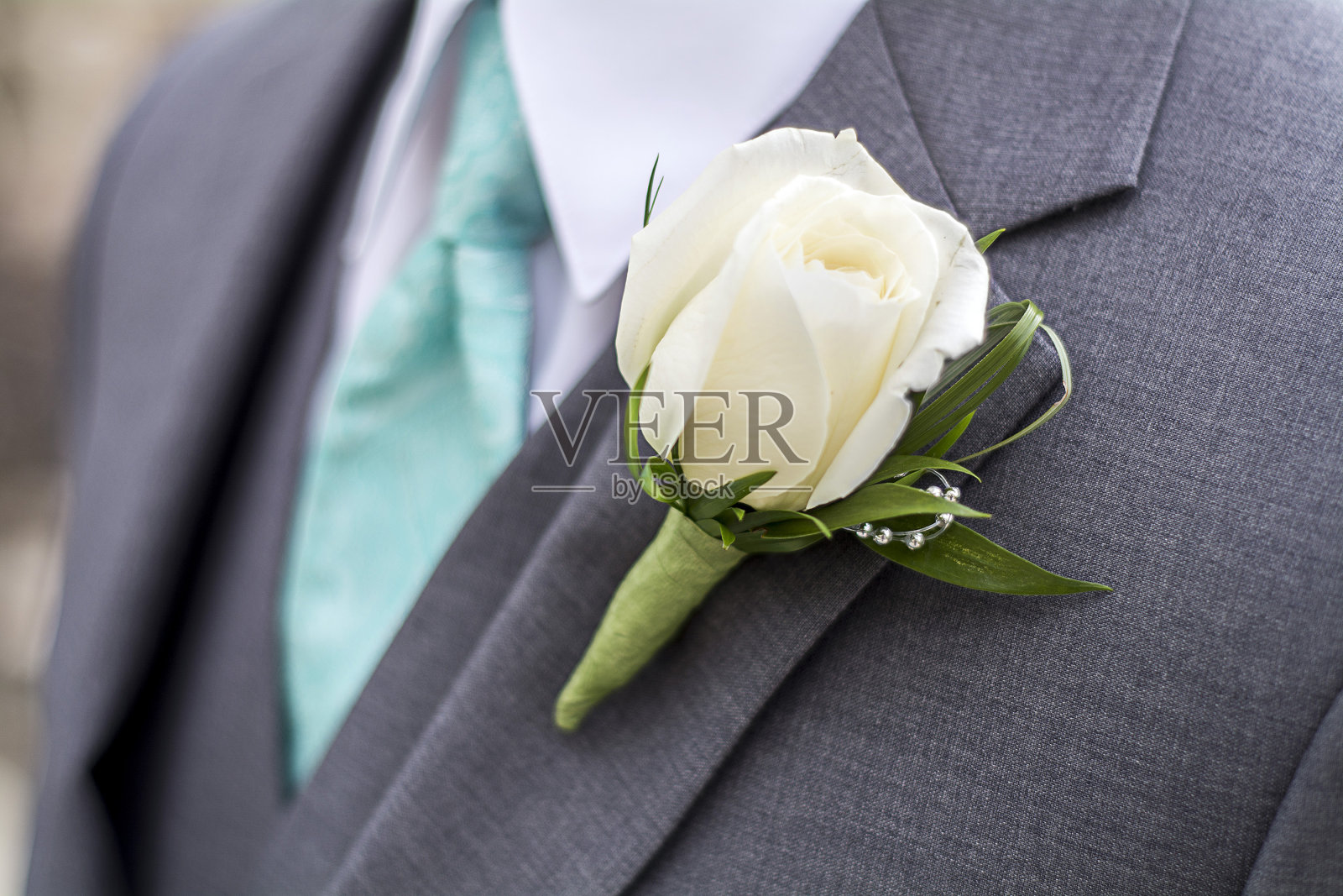 灰色西装和玫瑰胸花的男性照片摄影图片