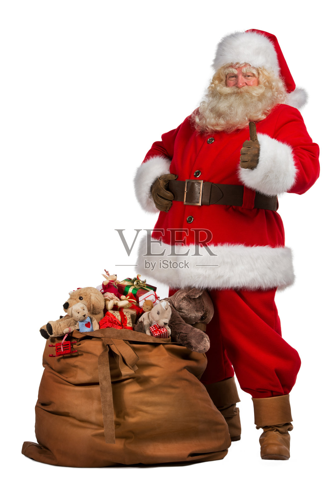 圣诞老人竖起大拇指，旁边是一个装满礼物的大袋子照片摄影图片