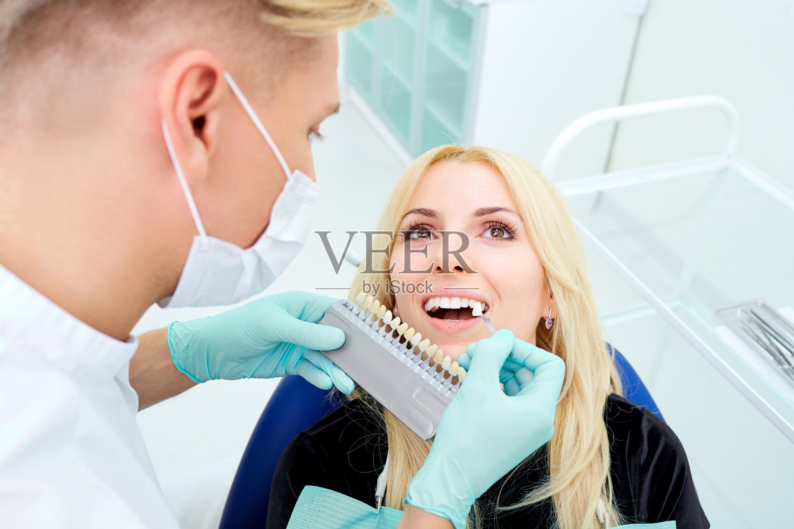 牙科医生尽量选择牙齿的颜色和在办公室的客户照片摄影图片