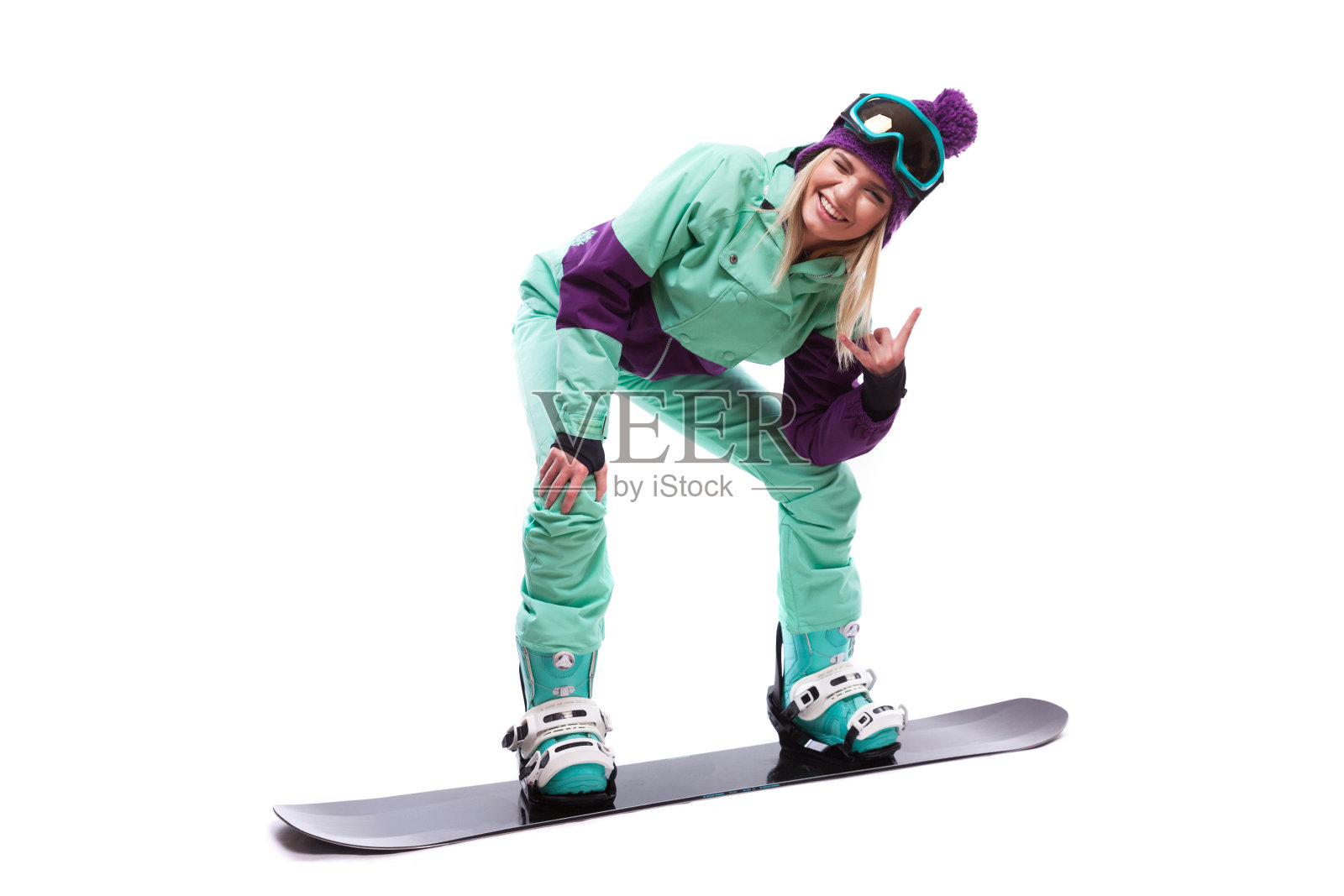 年轻漂亮的女人穿着紫色的滑雪服骑着滑雪板照片摄影图片