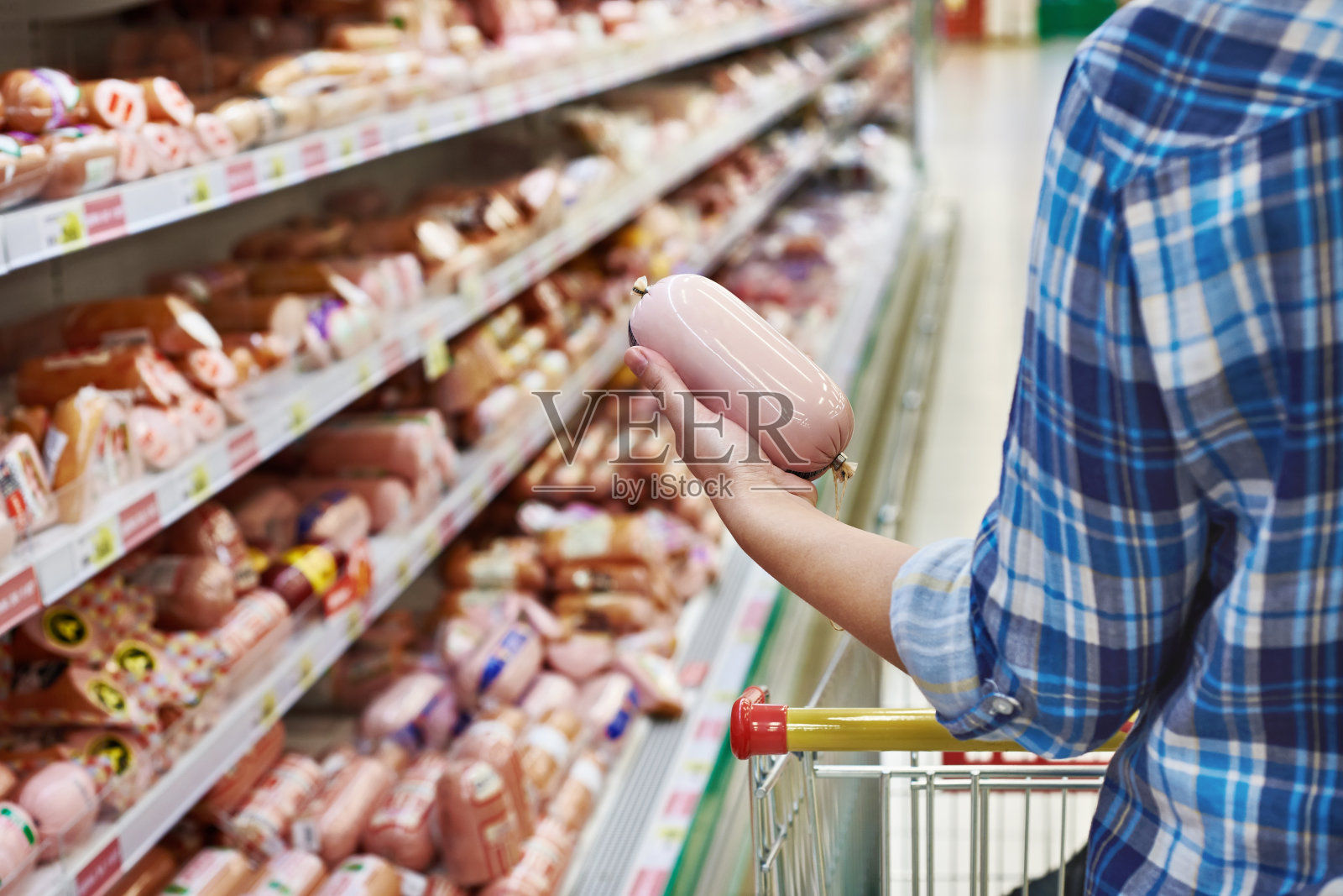 女人在超市买煮香肠照片摄影图片