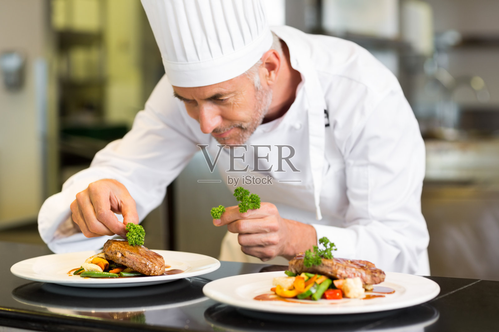 集中的男厨师在厨房装饰食物照片摄影图片