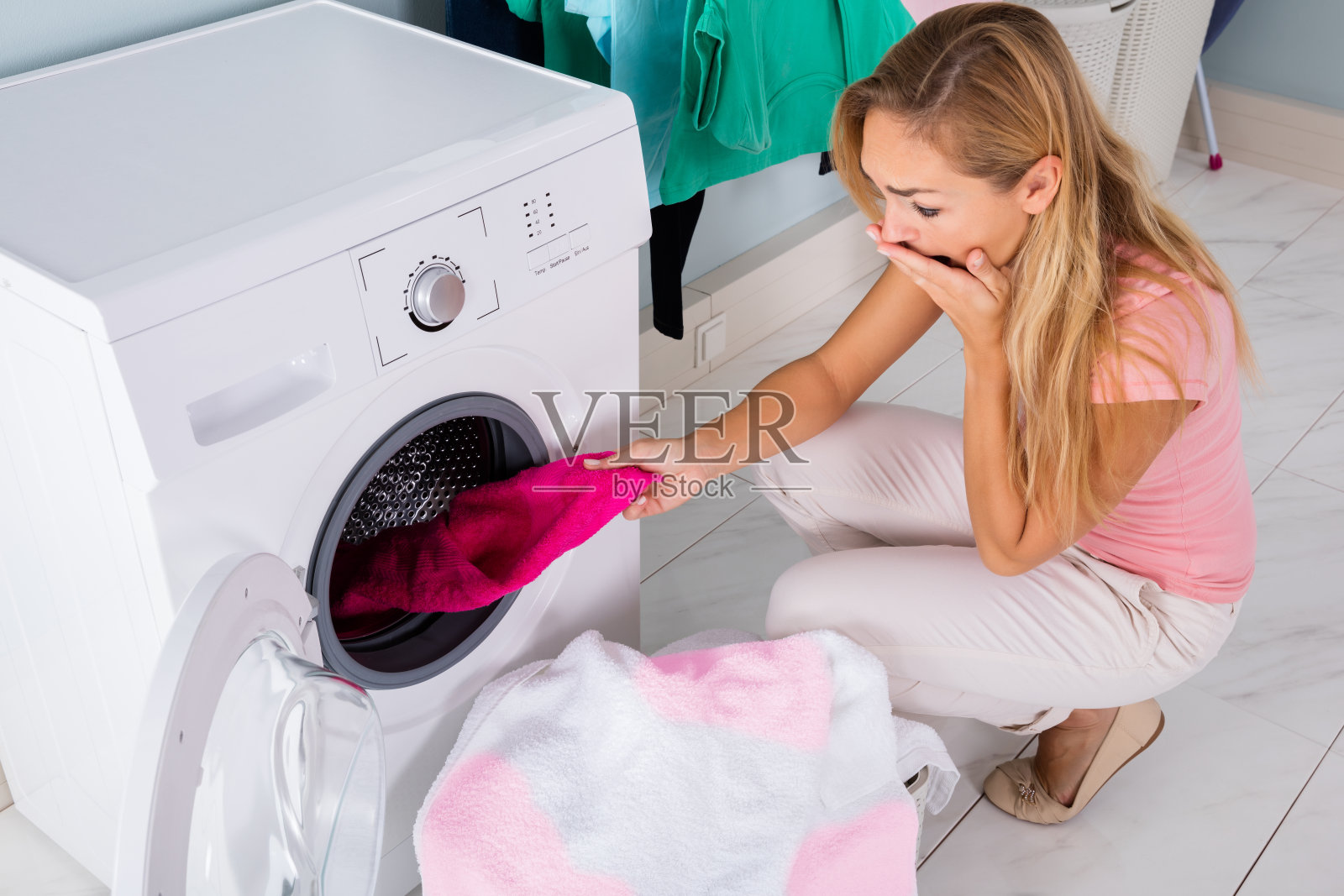 一个女人在洗衣机里看脏布照片摄影图片
