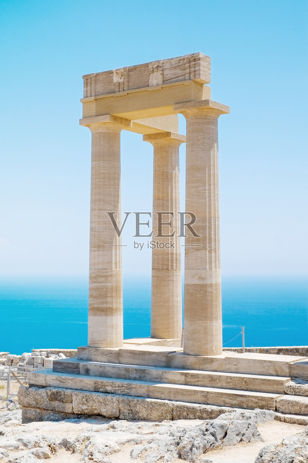 希腊林多斯卫城著名的希腊神庙柱，映衬着湛蓝的天空和大海照片摄影图片