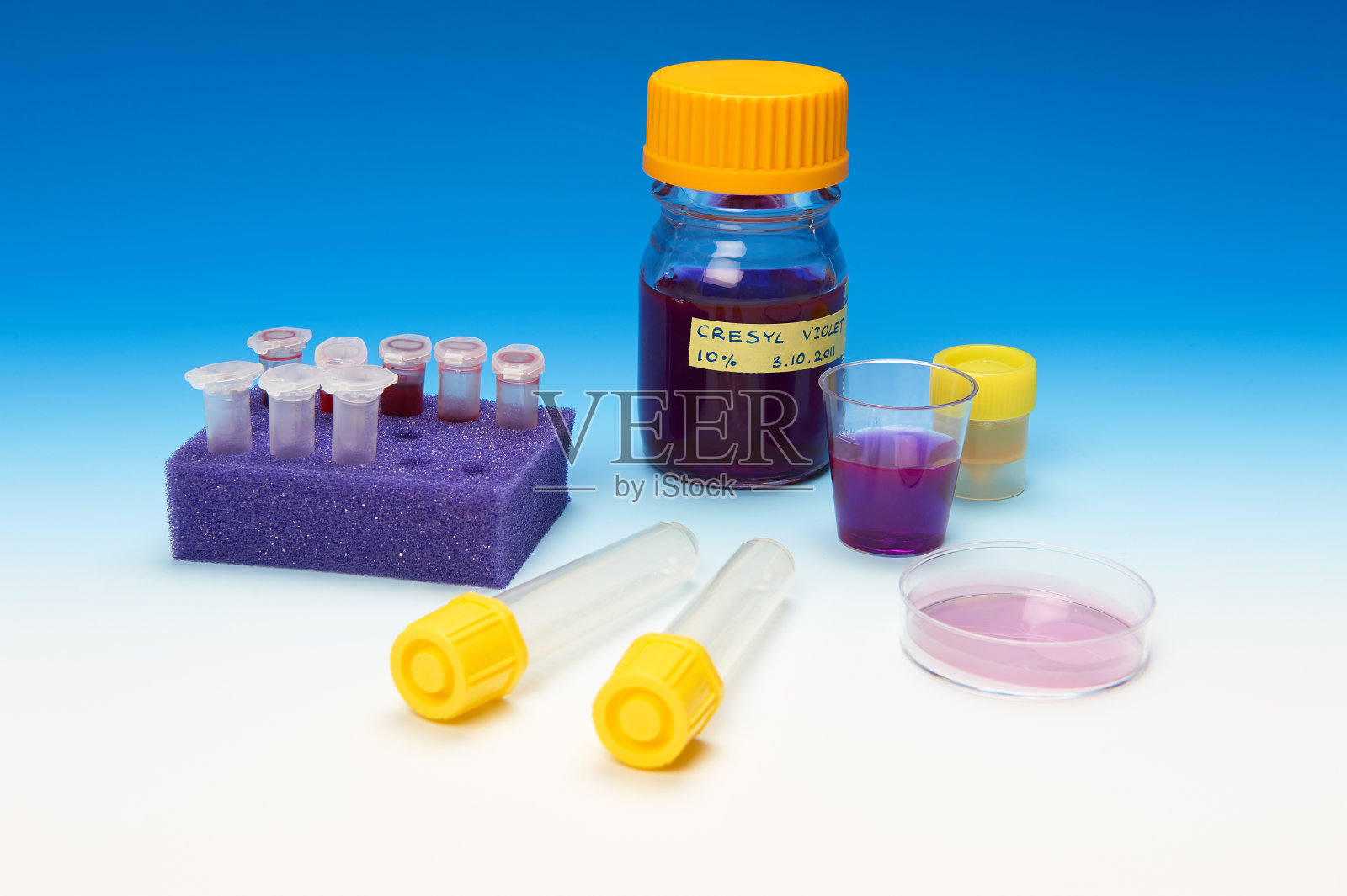患者显微镜下的样本和蓝色背景上的染色溶液照片摄影图片
